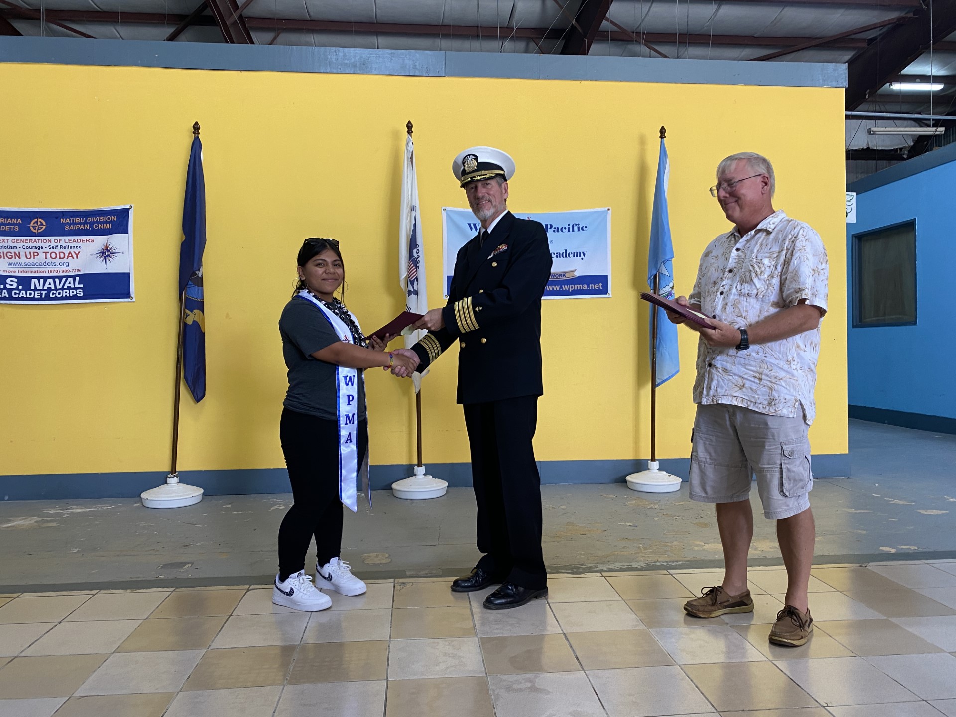 Leanalyn Reyes receives her Western Pacific Marine Academy graduation certificate from Capt. Michael Bacher.