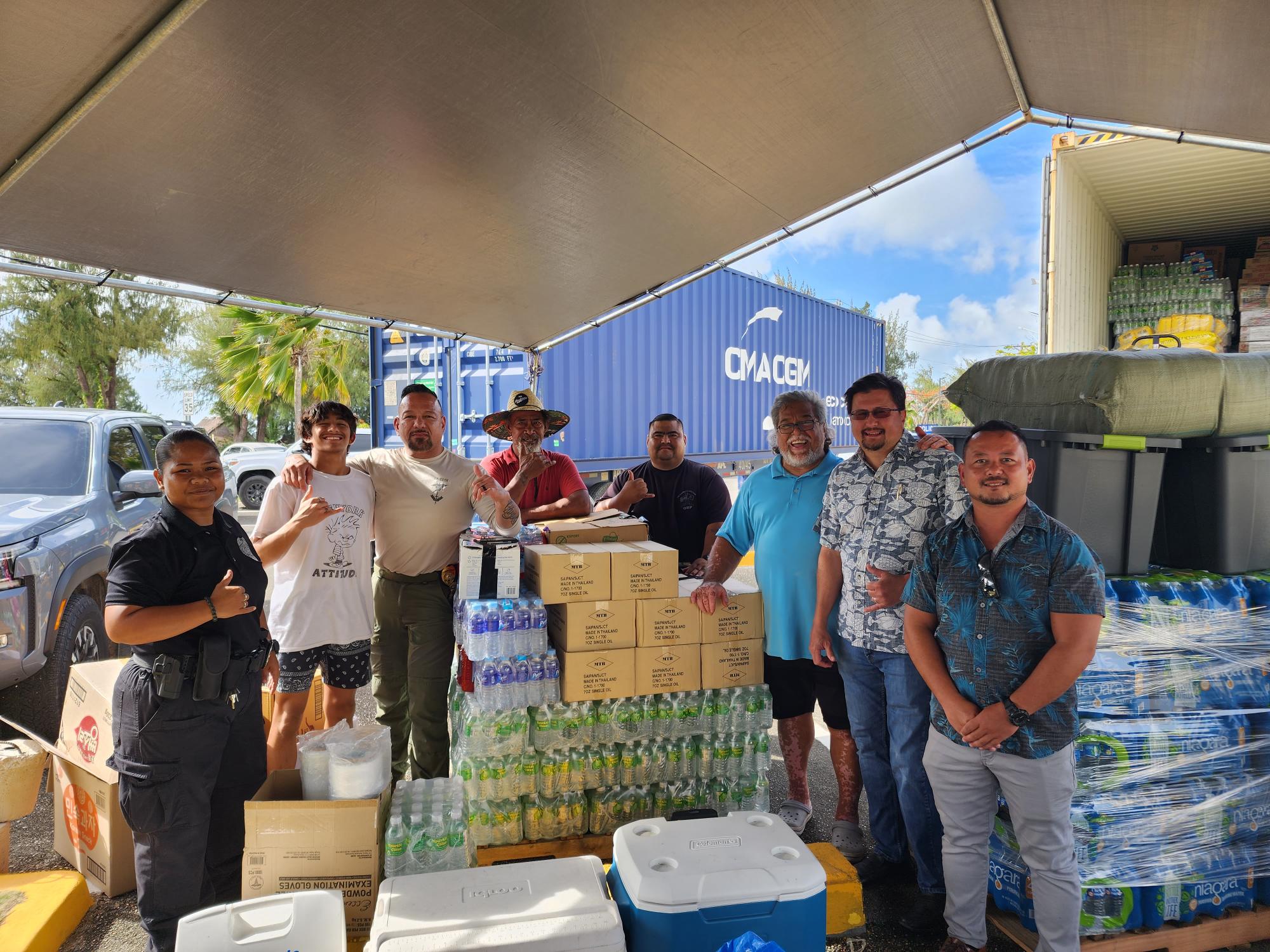 Corrections Commissioner Anthony Torres, KKMP’s Gray Sword, House Floor Leader Edwin Propst and Vice Speaker Joel Camacho pose with volunteers in the multi-purpose center parking lot where they are accepting donations for Guam’s typhoon victims.