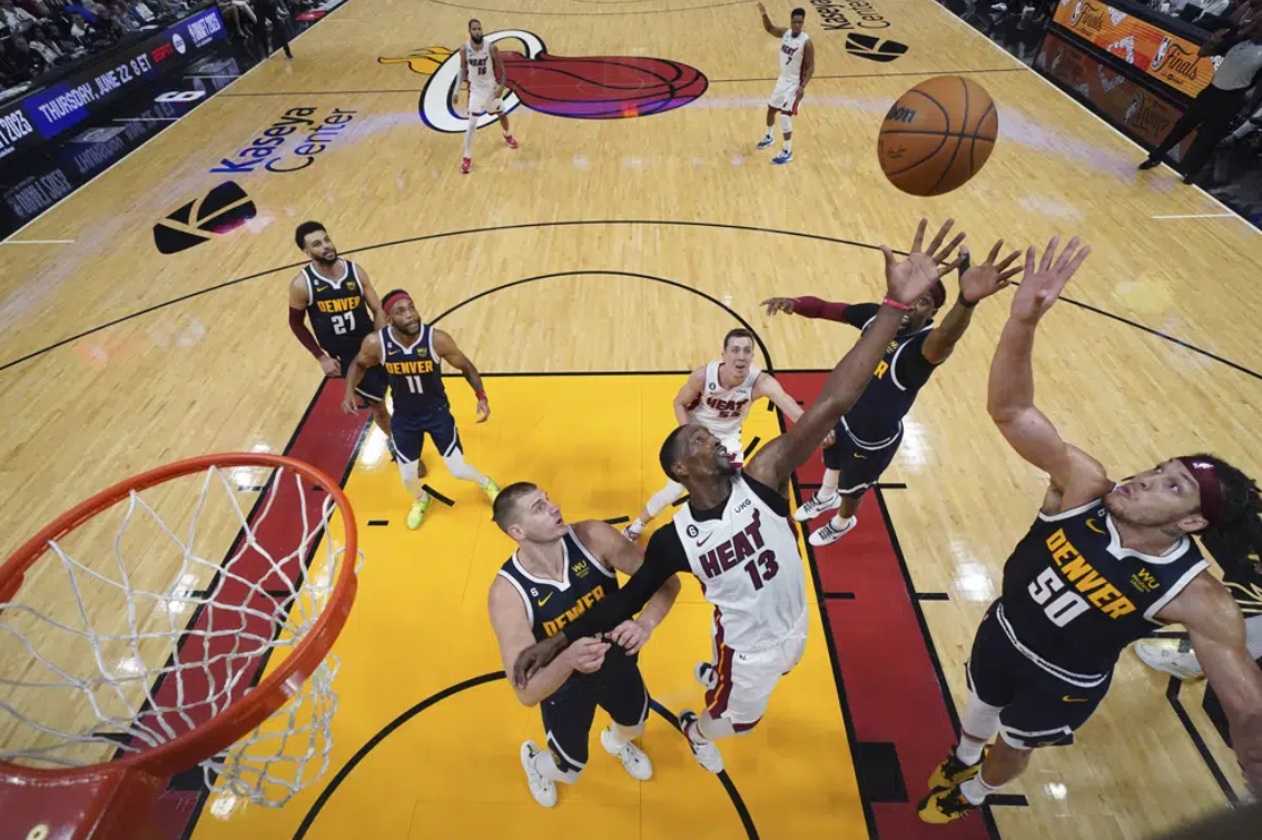 Miami Heat center Bam Adebayo (13) and Denver Nuggets forward Aaron Gordon (50) reach for the ball during the second half in Game 4 of the basketball NBA Finals, Friday, June 9, 2023, in Miami.