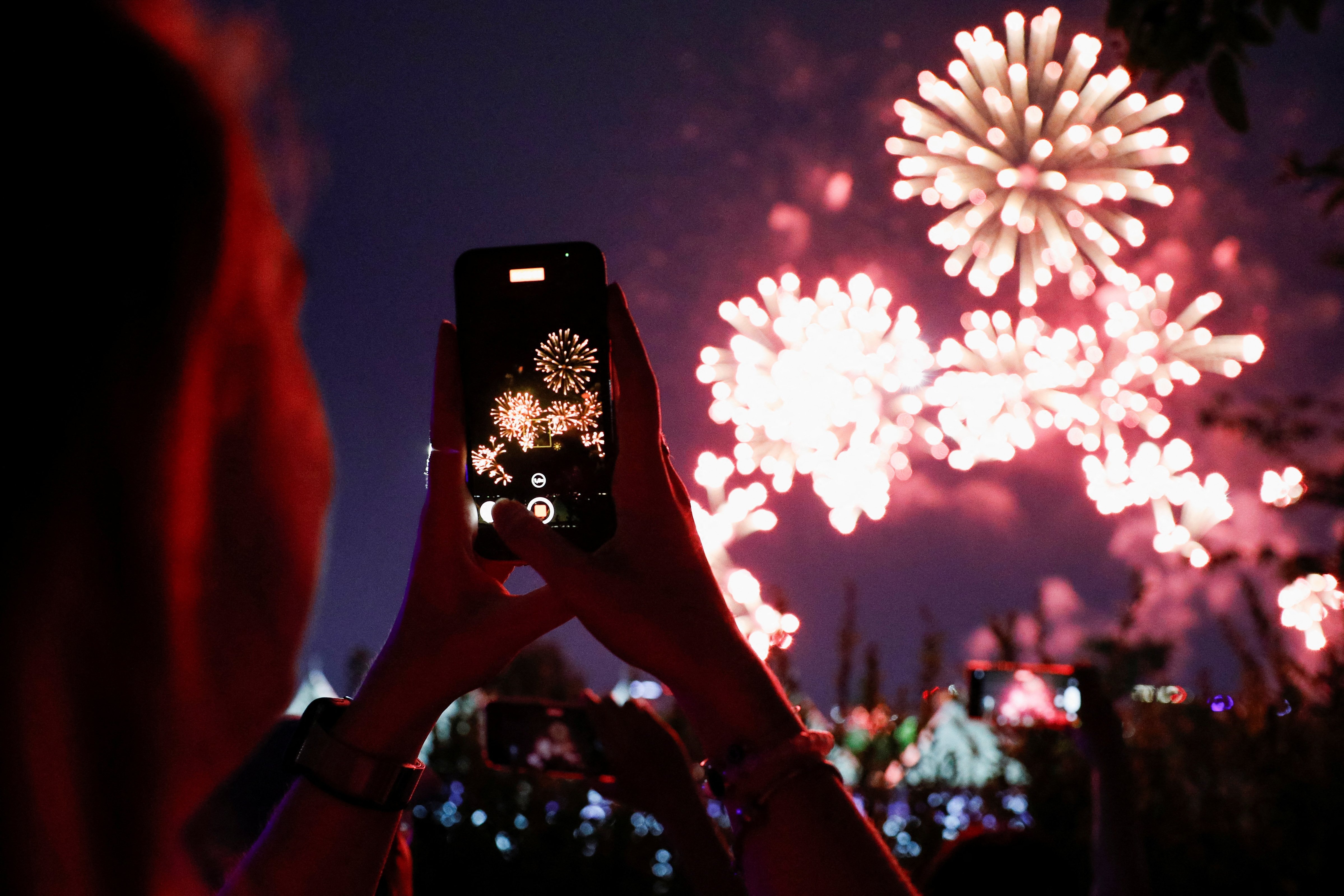 A fan of the K-pop boy band BTS takes pictures of fireworks during BTS 10th Anniversary FESTA in Seoul, South Korea, June 17, 2023. REUTERS/Kim Soo-hyeon