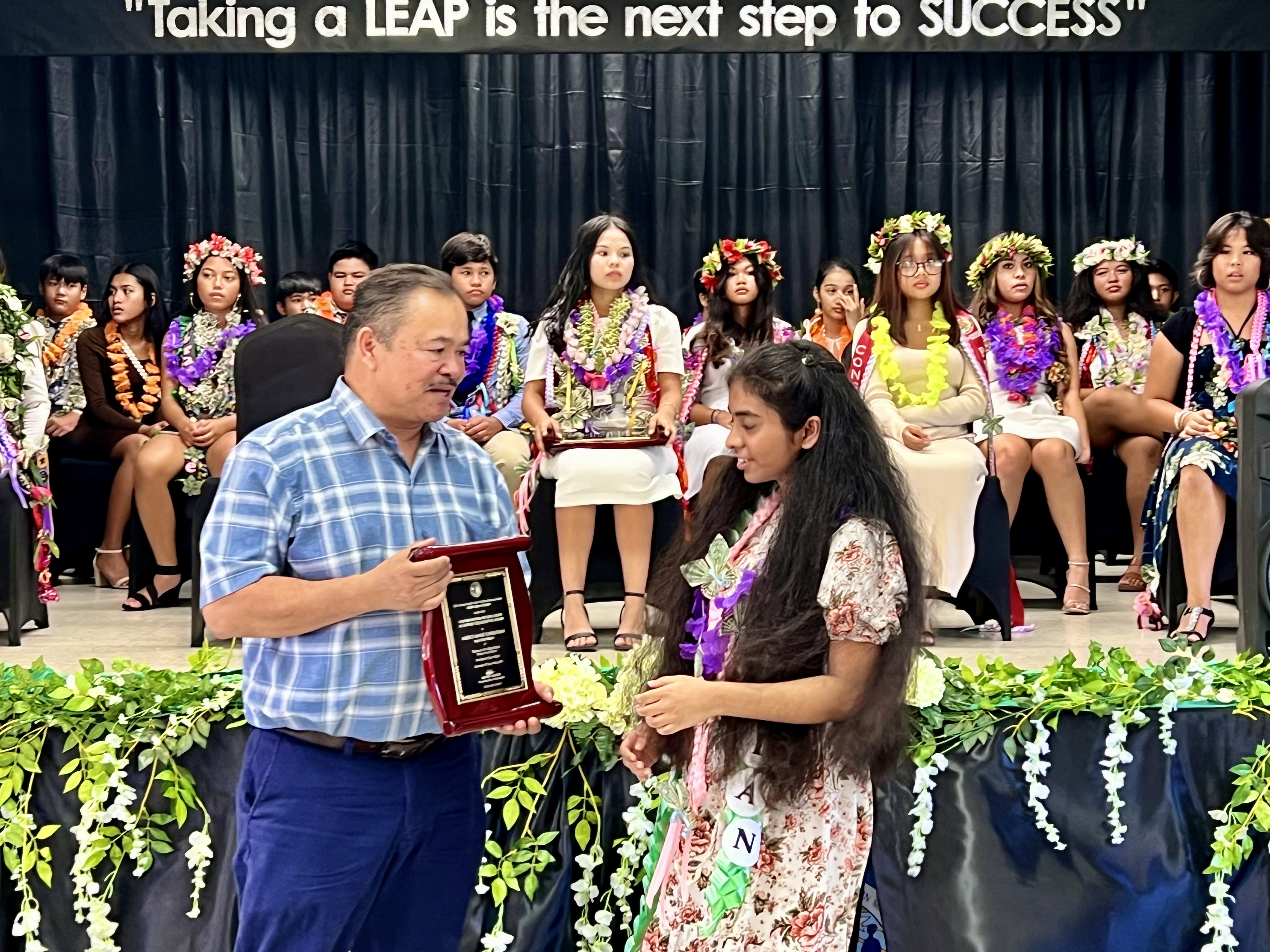 Salutatorian Mercy Anne Christian receives the Commissioner of Education Academic Award from Commissioner of Education Dr. Alfred B. Ada.