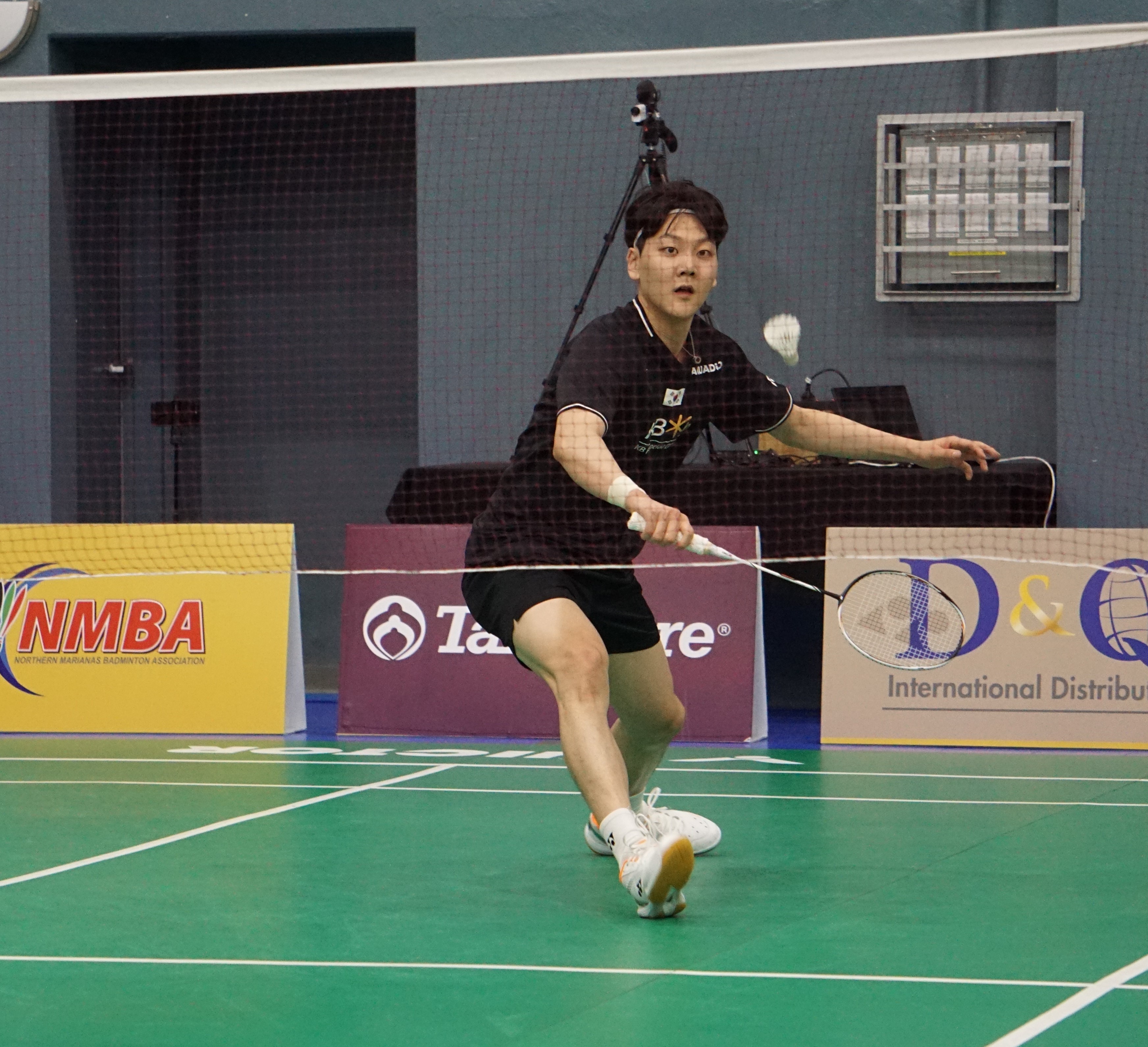 Lee Yun Gyu of South Korea steps forward for the backhand return during a Crowne Plaza Northern Marianas Open match Monday at the Ada gym.