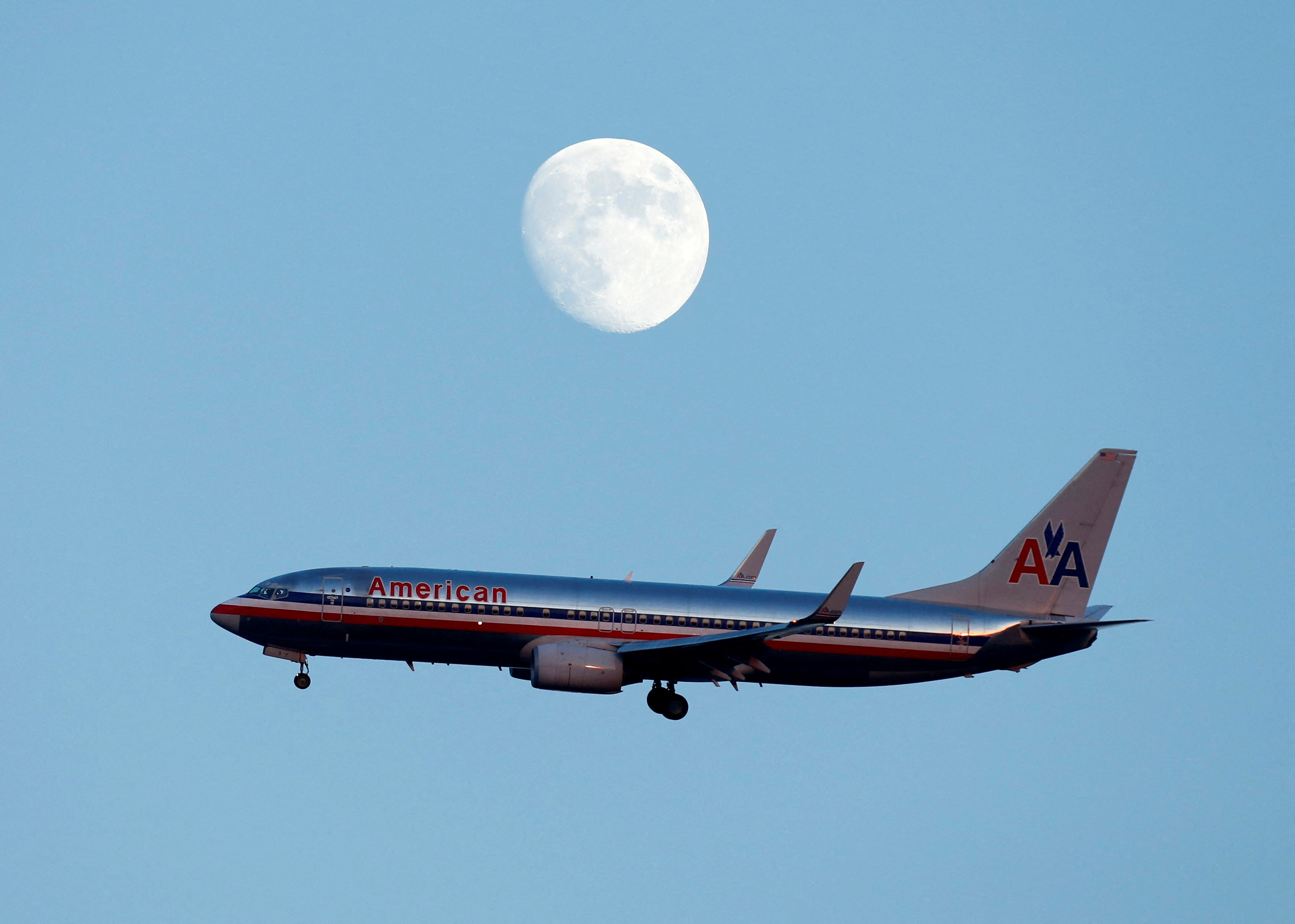 An American Airlines passenger jet glides in under the moon as it lands at LaGuardia airport in New York, New York, August 28, 2012. REUTERS/Eduardo Munoz/File Photo