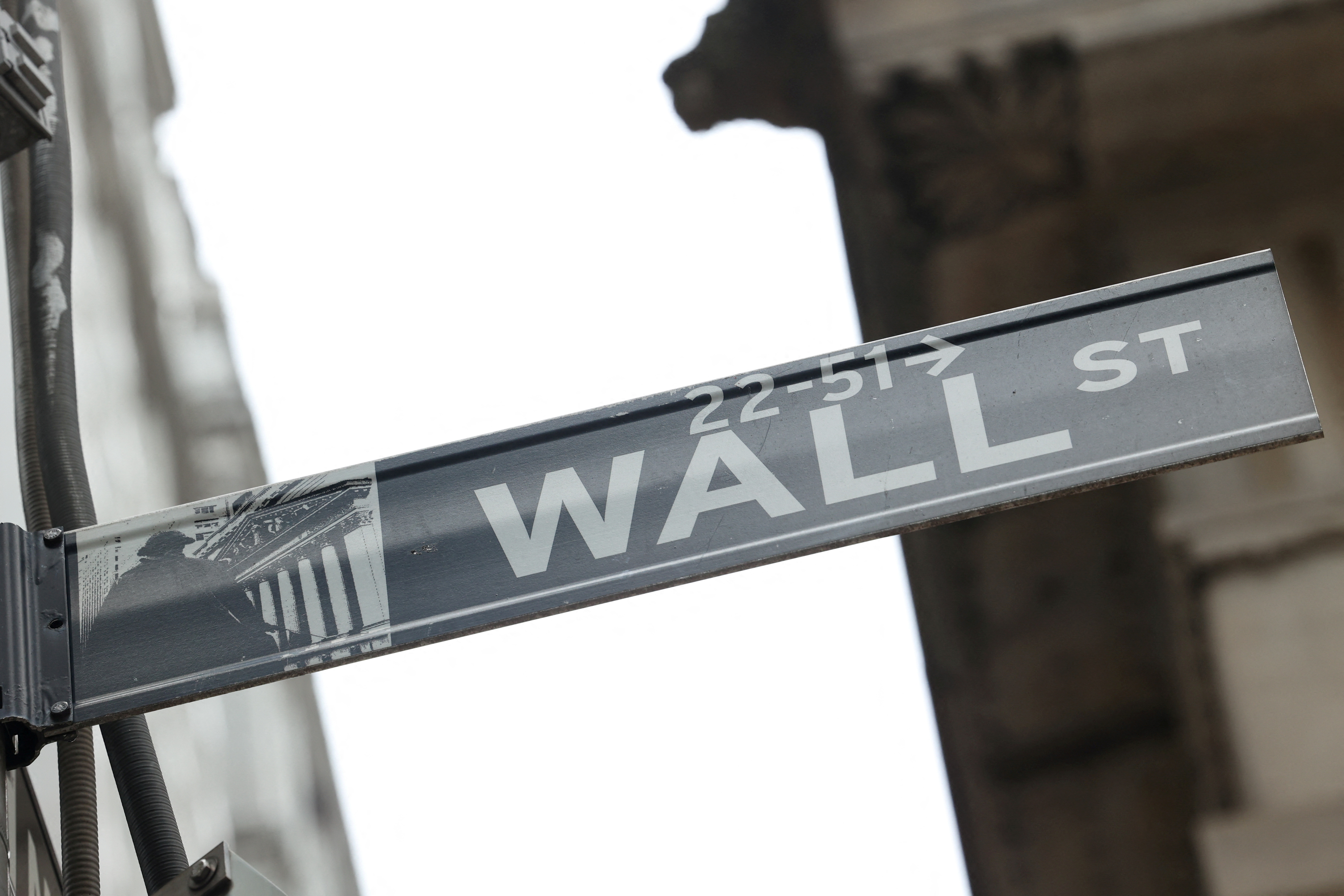 A street sign marks Wall Street outside the New York Stock Exchange (NYSE) in New York City, where markets roiled after Russia continues to attack Ukraine, in New York, U.S., February 24, 2022. REUTERS/Caitlin Ochs/File Photo