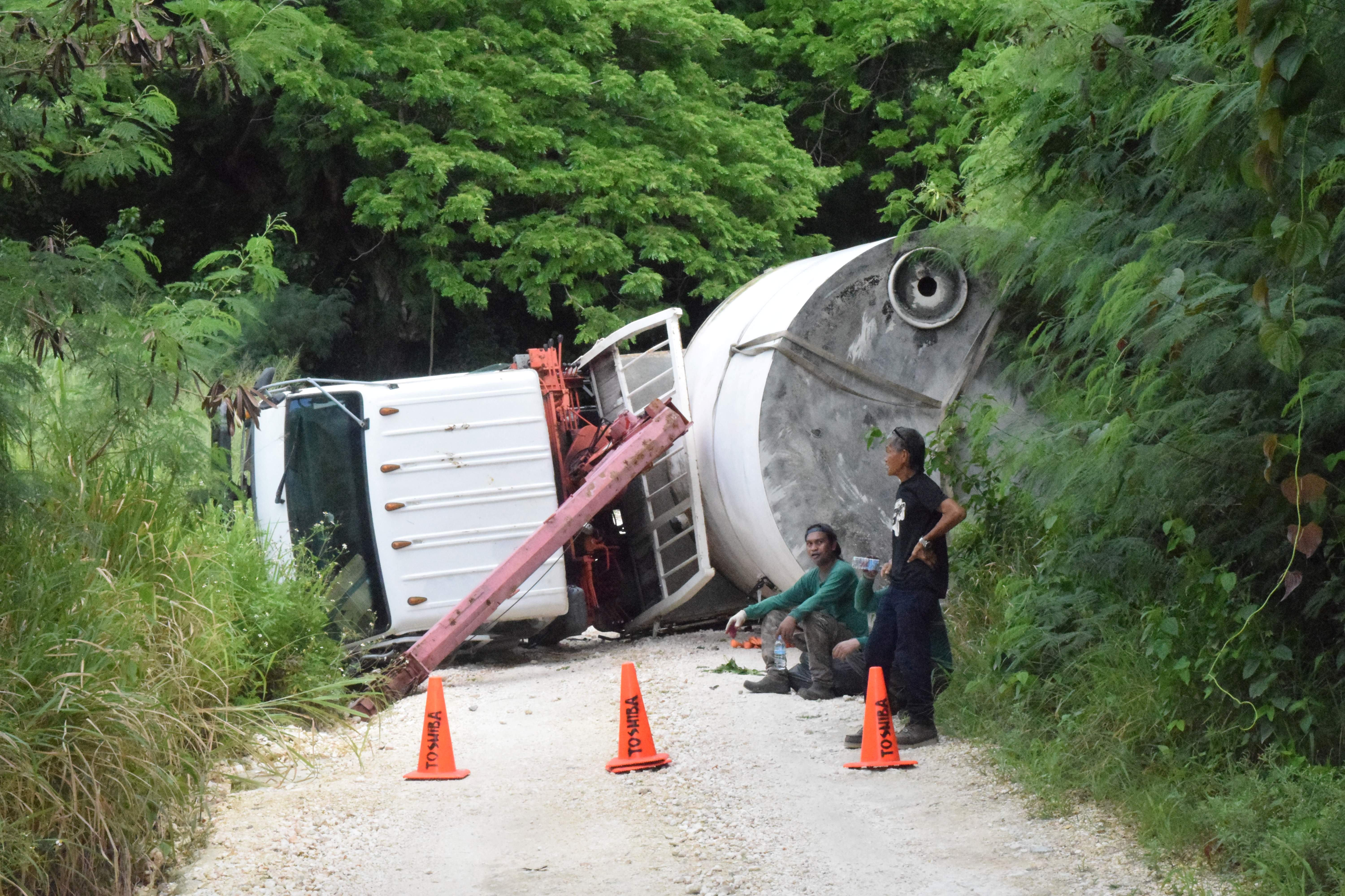 SG Auto Shop mechanics Remuel Maritano and Vicente Carolino are seen near the boom truck that blocked Earhart Drive in Gualo Rai on July 14, 2023.