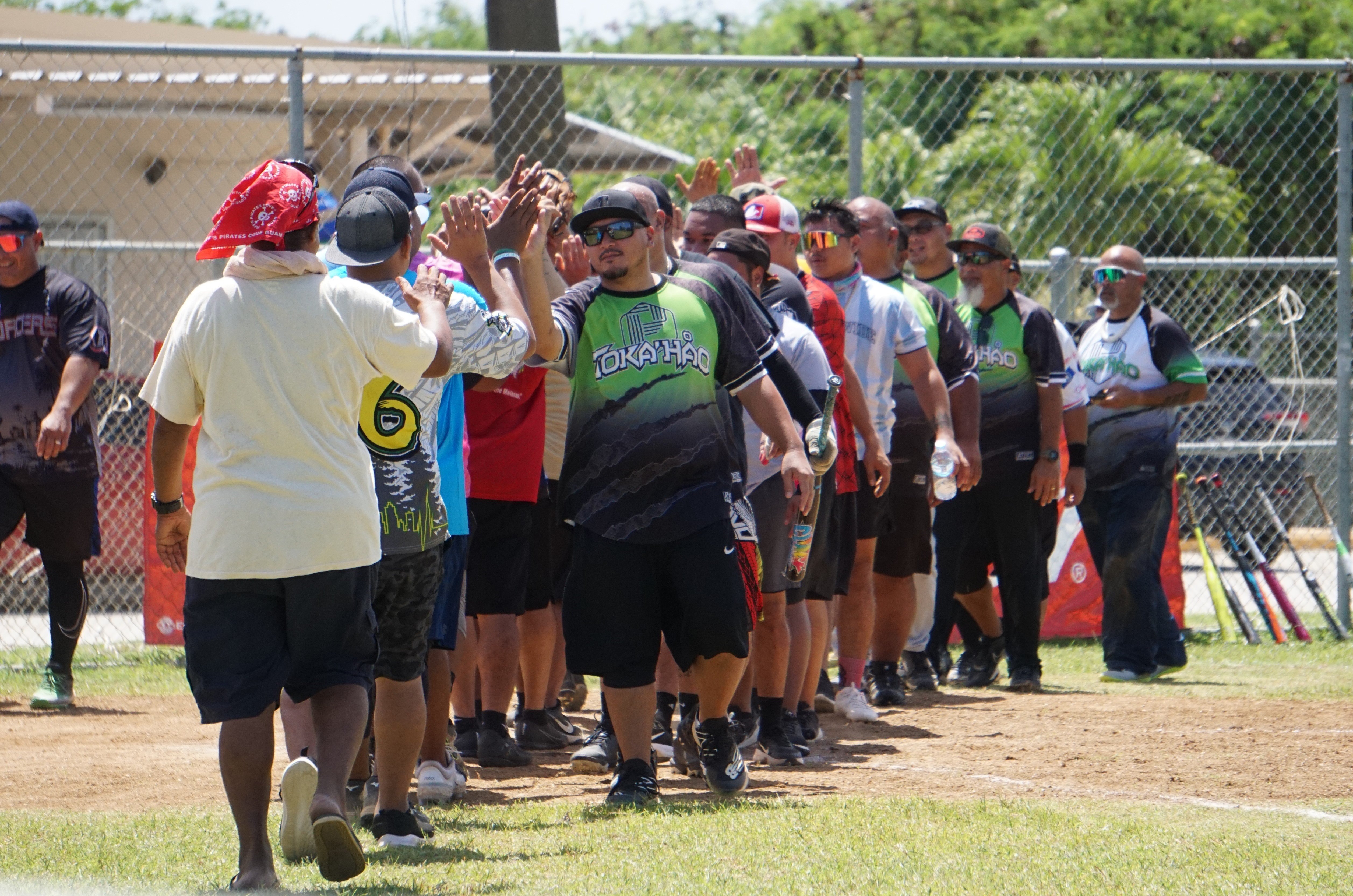 Payday Hao and No Excuse players exchange high-fives after their 2023 Budweiser Belau Amateur Softball Association Open League game Sunday at the Dandan baseball field.