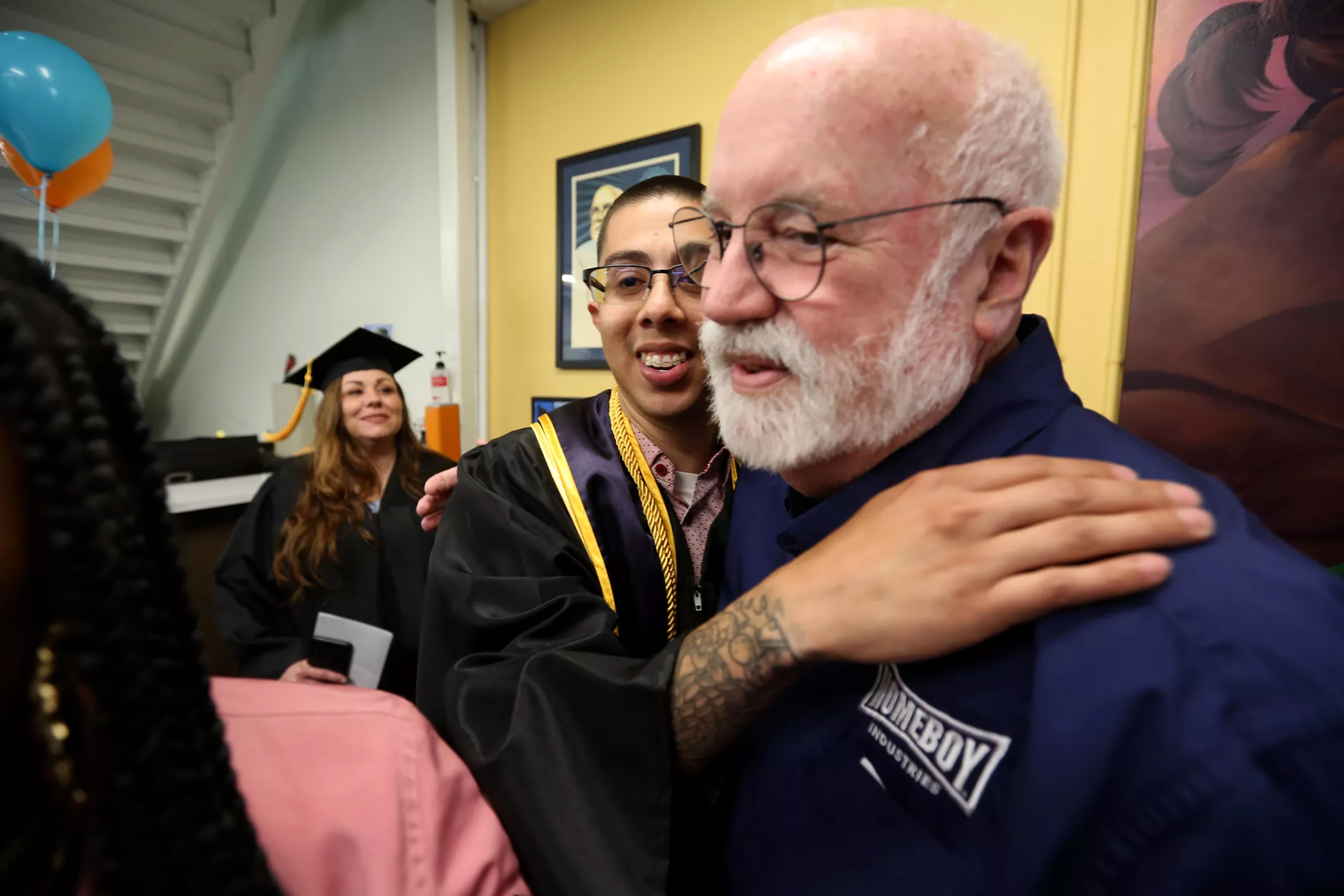 Jessi Fernandez, center, hugs Father Greg Boyle before Homeboy Industriesâ€™ celebration of Class of 2023 graduates. (Genaro Molina/Los Angeles Times/TNS)