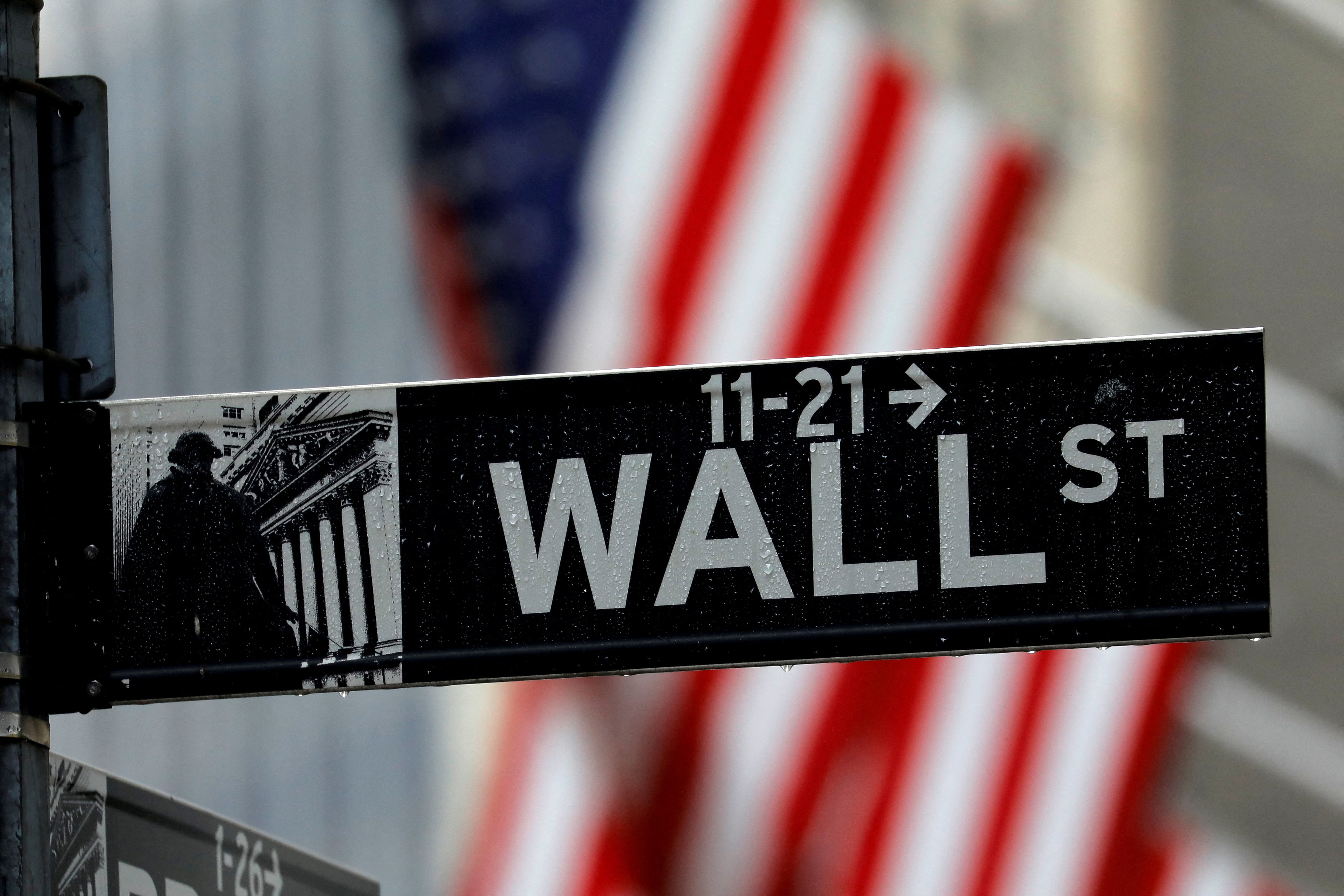 Raindrops hang on a sign for Wall Street outside the New York Stock Exchange in Manhattan in New York City, New York, U.S., October 26, 2020. REUTERS/Mike Segar/file photo