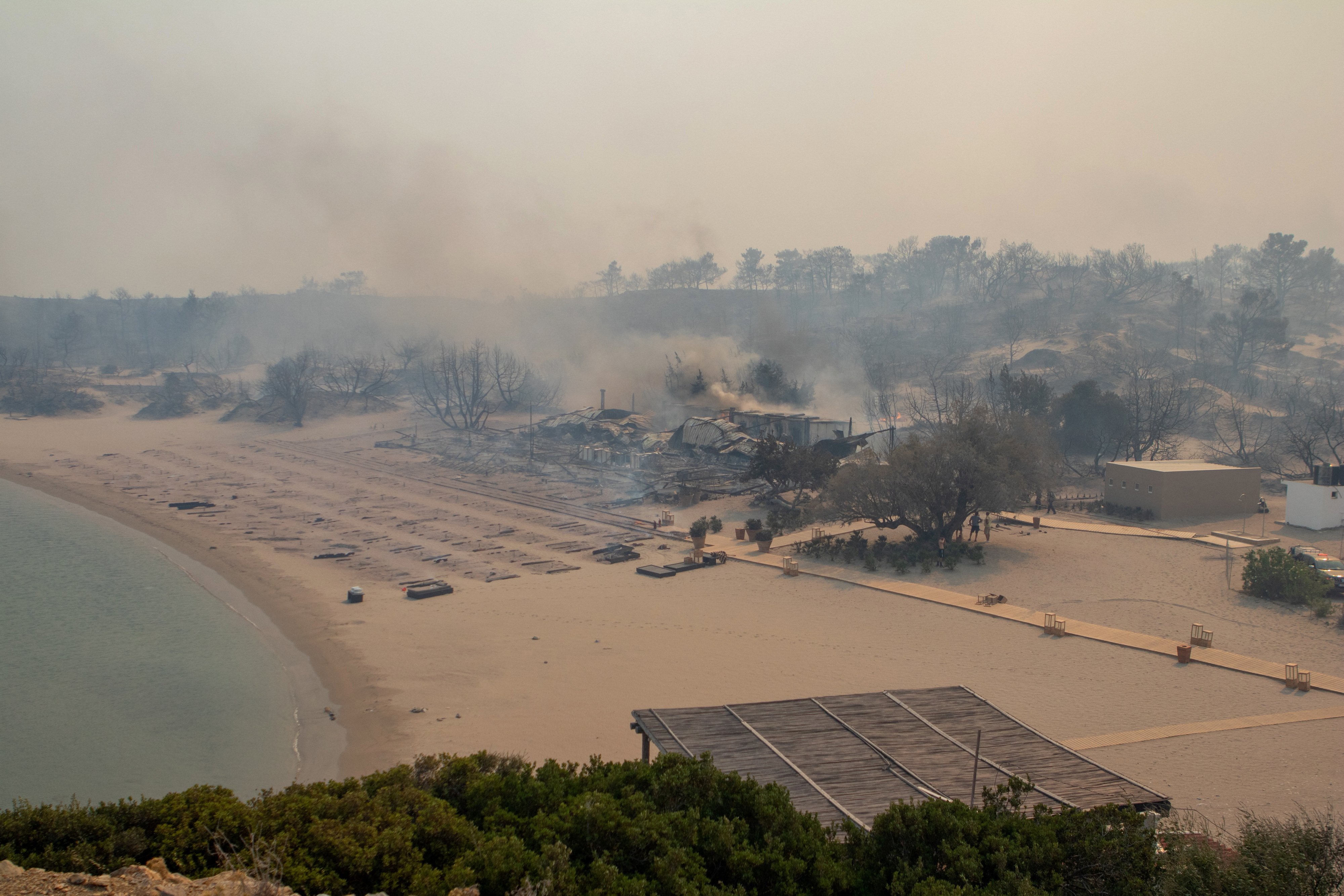 A wildfire burns next to a beach near Lindos, on the island of Rhodes, Greece, July 22, 2023. REUTERS/Lefteris Damianidis