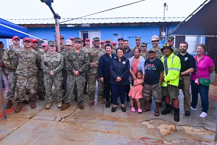 Gov. Lou Leon Guerrero, standing next to Fely and Sonny Baza, along with dozens of personnel from the Federal Emergency Management Agency, Army Corps of Engineers, Guam National Guard and other partners, gather for a photo during a completion ceremony for the last RISE UP roof repair Thursday, July 27, 2023.