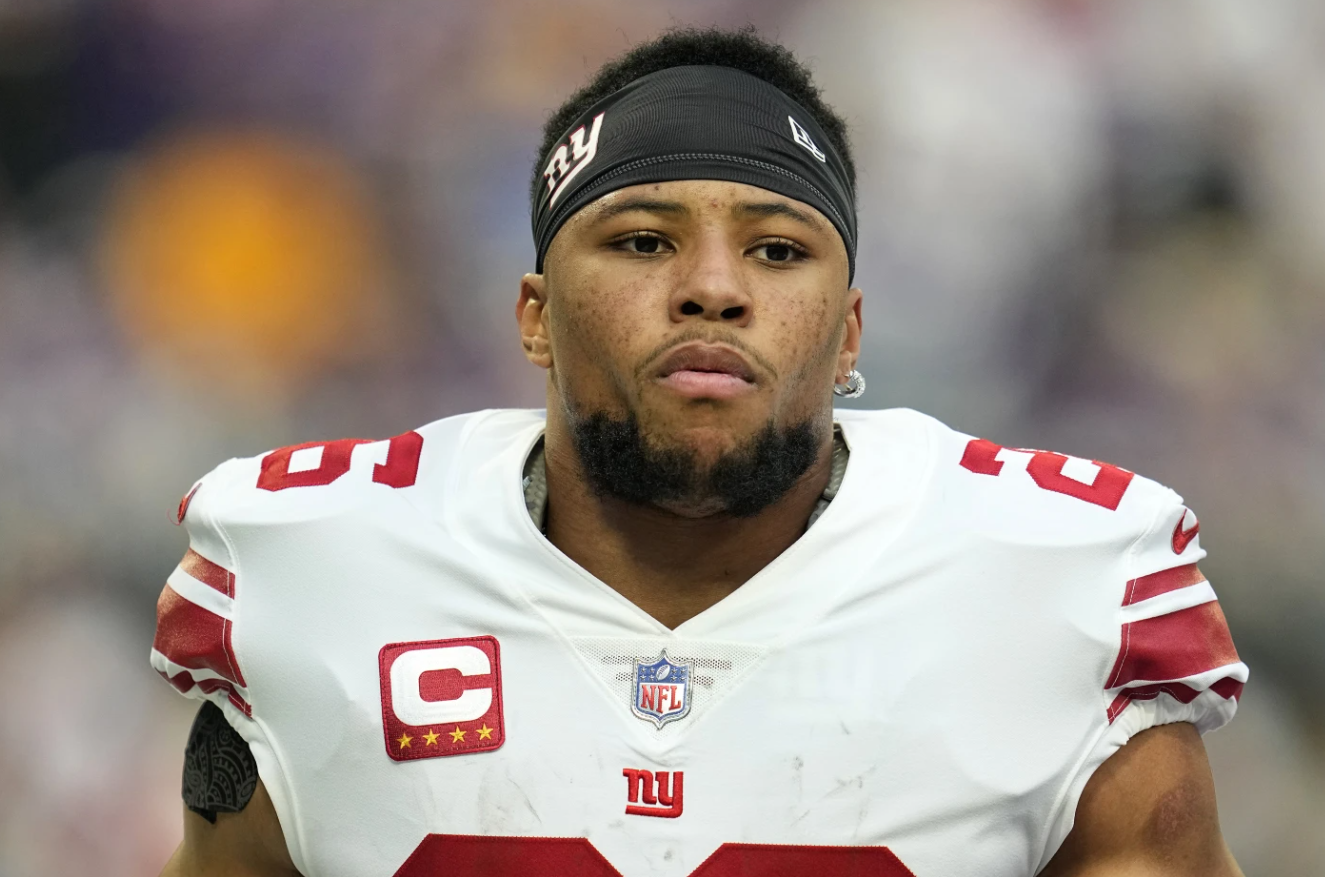 New York Giants running back Saquon Barkley walks across he field before an NFL wild-card football game against the Minnesota Vikings on Jan. 15, 2023 in Minneapolis.