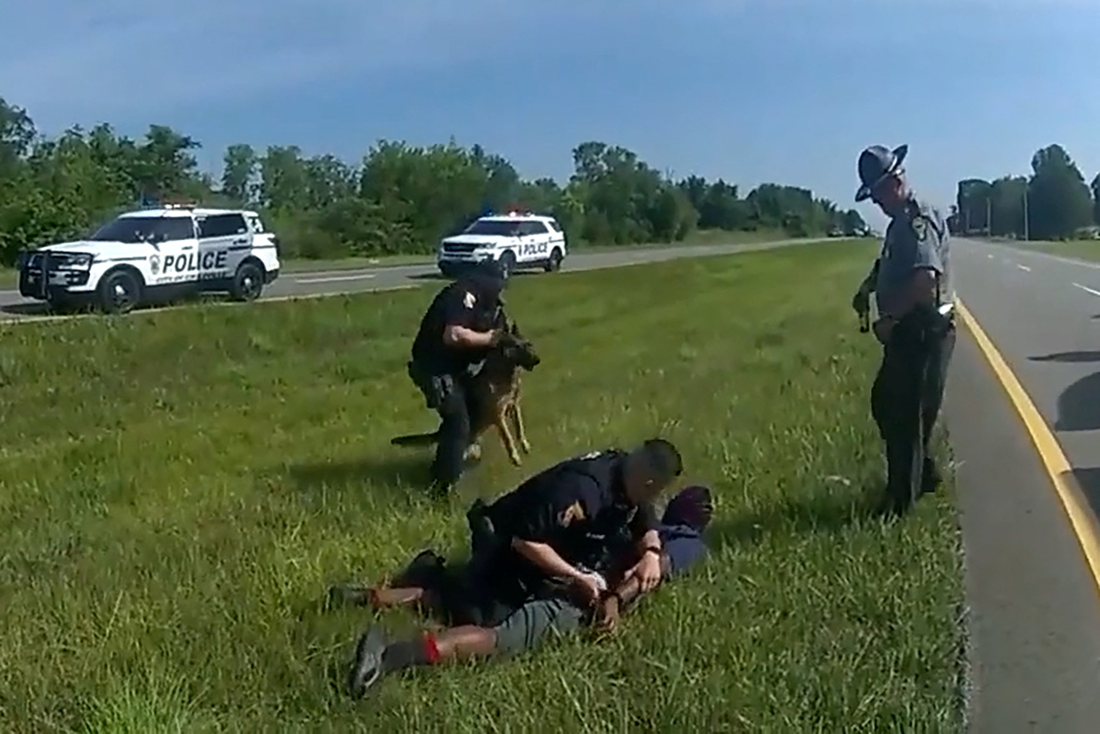 Truck driver Jadarrius Rose, 23 is handcuffed by an Ohio State Highway Patrol (OSHP) officer as a police dog is held back after Rose was attacked by the animal during a traffic stop south of Columbus, Ohio, U.S. July 4, 2023 in a still image from police body camera video. Ohio State Highway Patrol/Handout via REUTERS