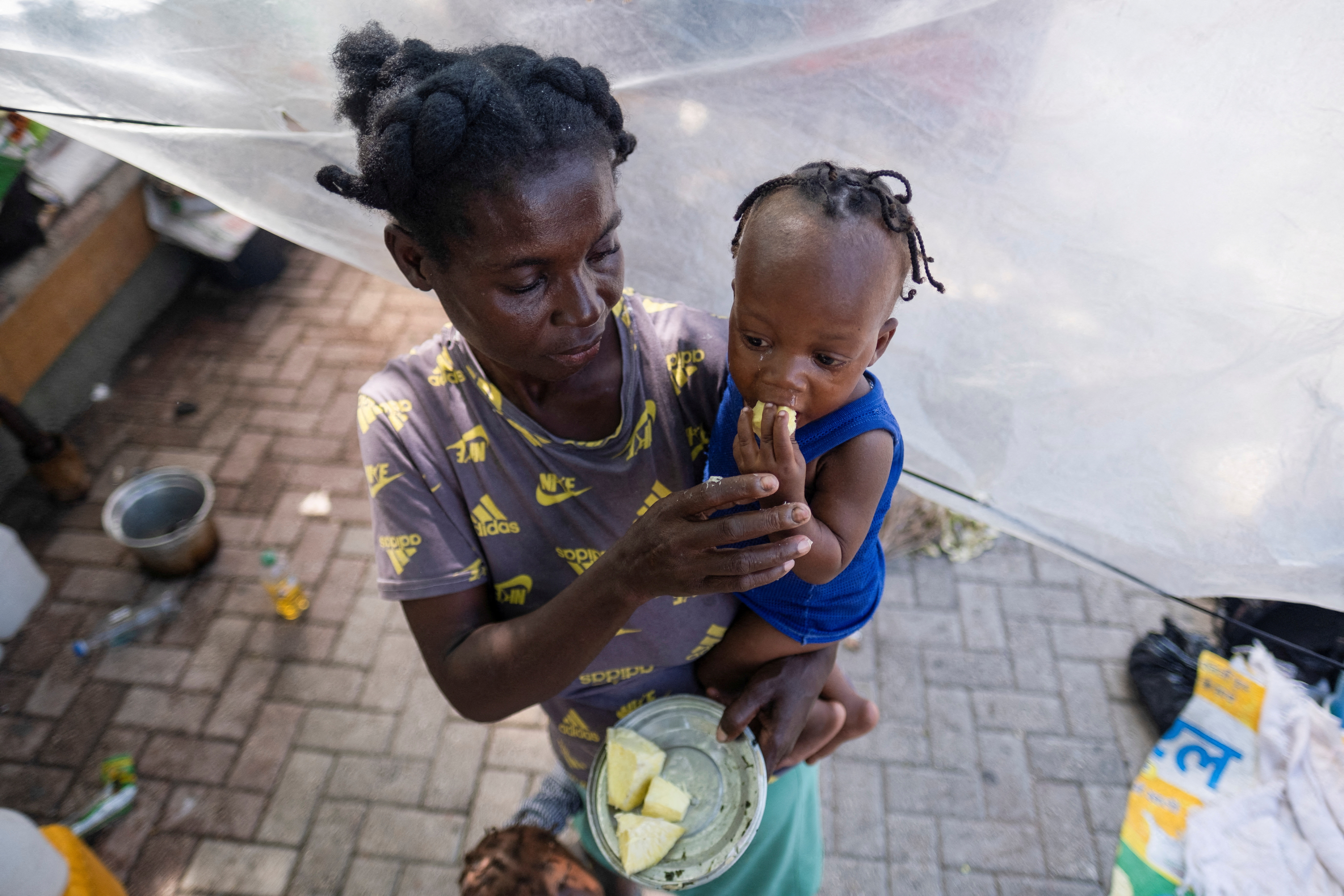 FILE PHOTO: A woman feeds her baby at the Hugo Chavez Square where they shelter from gang war violence in Port-au-Prince, Haiti October 16, 2022. REUTERS/Ricardo Arduengo/File Photo