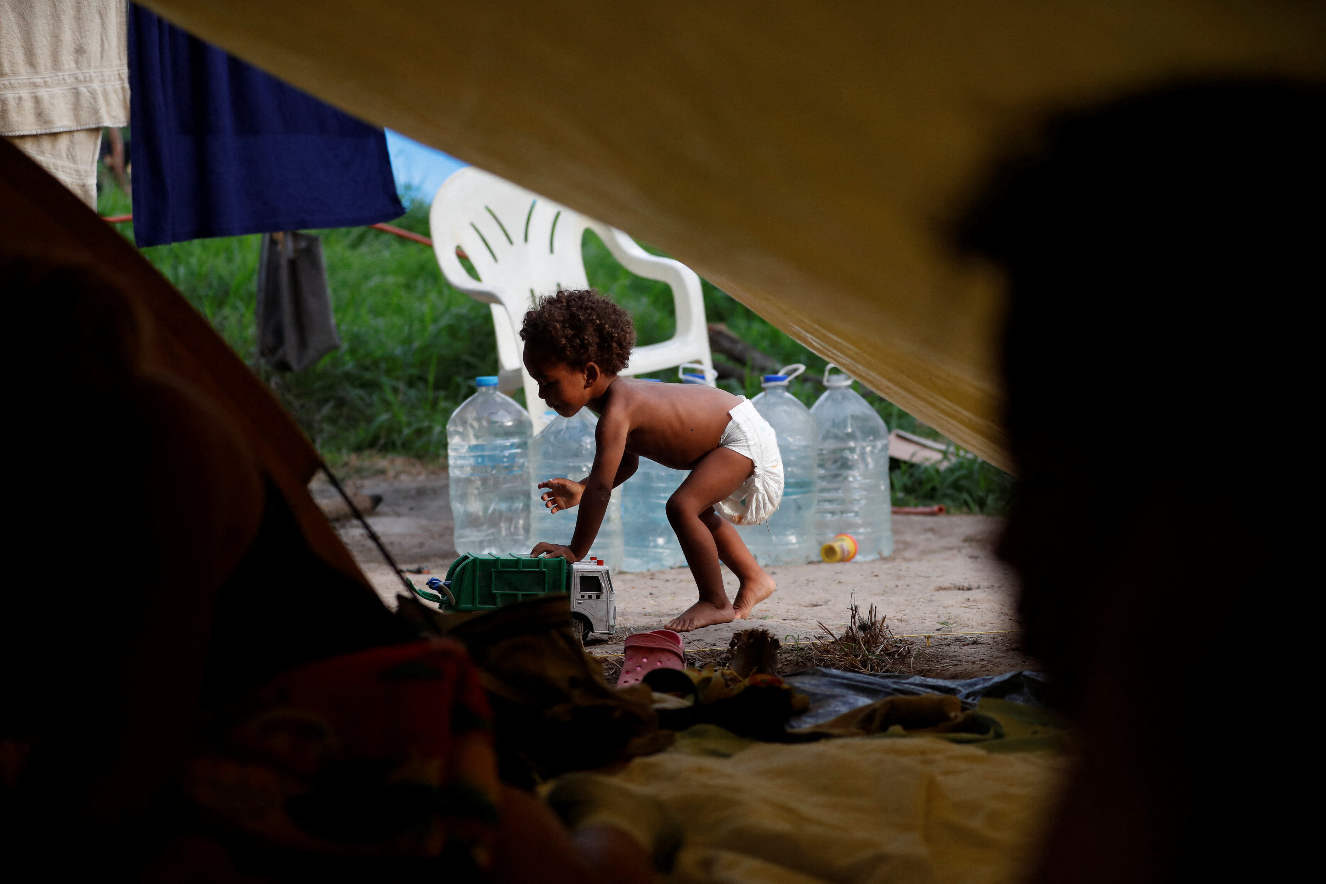 Asylum seeker Natanael, 1, whose mom is Venezuelan but who was born in Colombia, plays with a toy car next to his tent while he and his family wait to attempt to cross into the U.S. by an appointment through the Customs and Border Protection app, called CBP One, at a makeshift camp, in Matamoros, Mexico June 20, 2023. By mid-June, the population of the Matamoros camp exceeded 5,000, according to Juan Rodriguez, head of the state-level migrant services agency, with an additional 3,000 migrants scattered across Matamoros in shelters, hotels, Airbnbs, abandoned houses, and an out-of-service gas station, local officials said. REUTERS/Daniel Becerril
