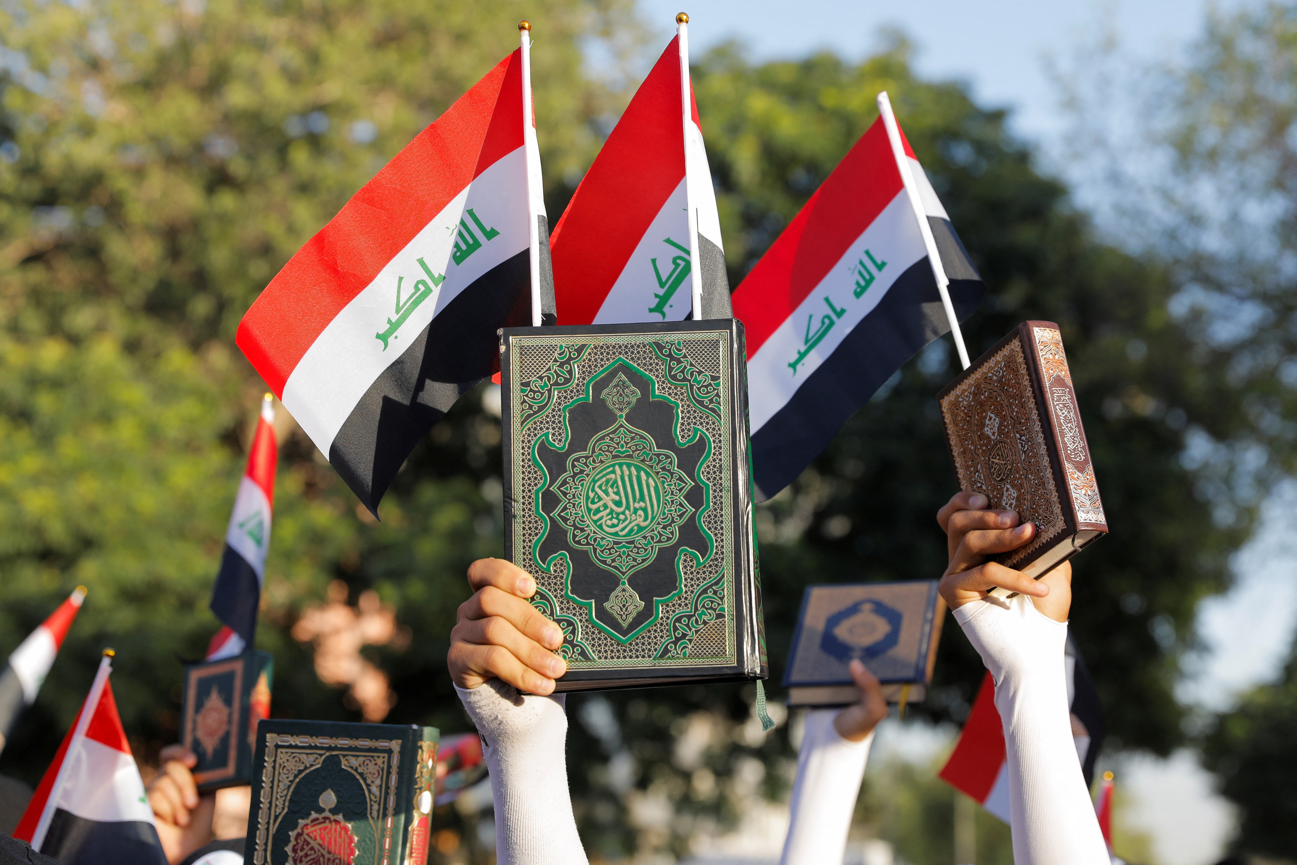 Iraqi demonstrators hold the Koran during a protest near the Green Zone against the burning of a copy of the Koran and the Iraqi flag in the Swedish capital Stockholm, in Baghdad, Iraq July 22, 2023. REUTERS/Khalid Al-Mousily