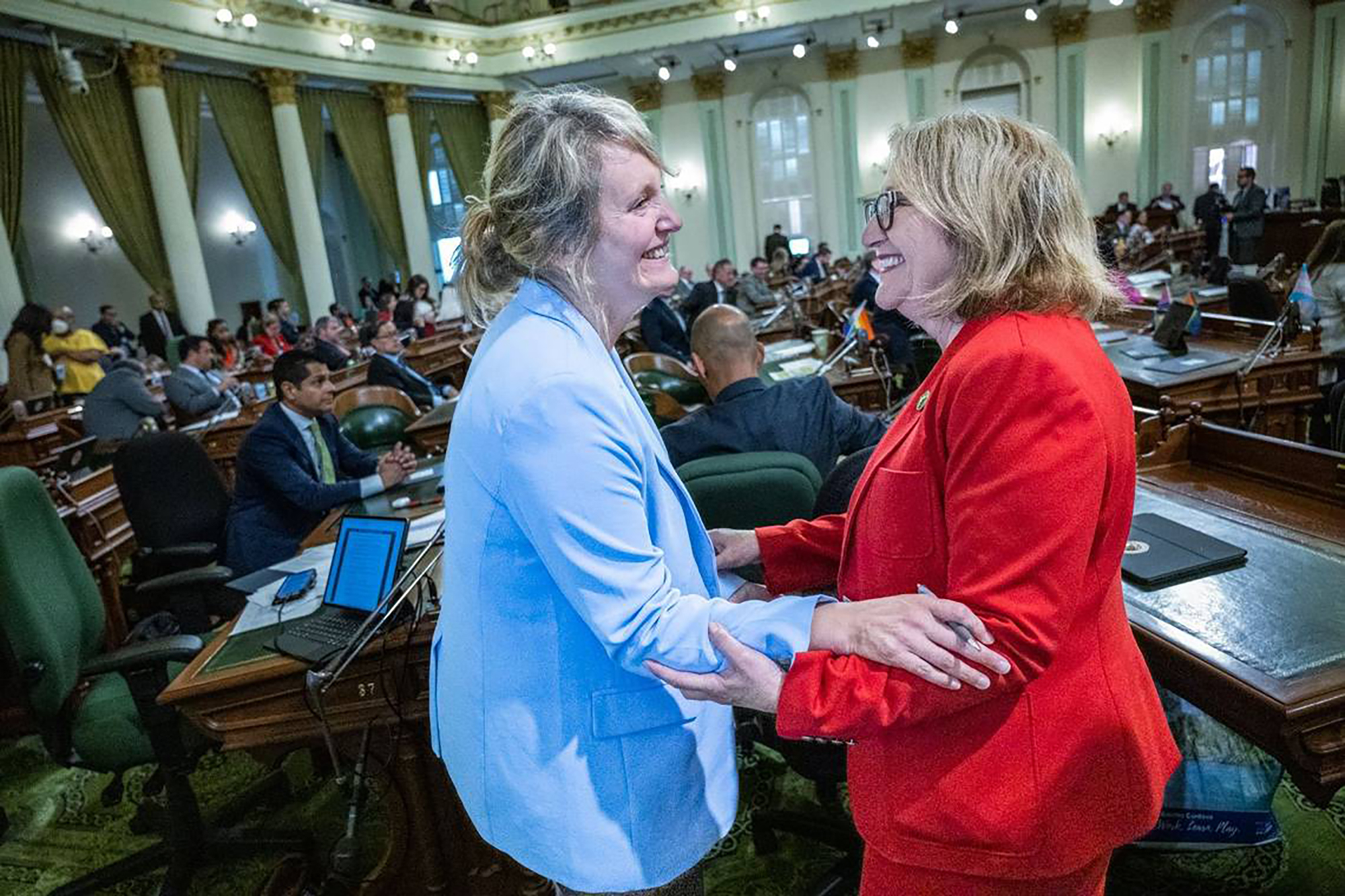 Assemblywoman Buffy Wicks, DD-Oakland, left, on June 1, 2023, celebrates the passing of her bill, the California Journalism Preservation Act, with Assemblywoman Eloise Gomez Reyes, D-Colton, at the California state capitol in Sacramento, California. The bill would require companies such as Meta, Google and Twitter to pay a percentage of their advertising revenue as a "journalism usage fee" to news organizations producing content that is shared on their platforms. The bill was placed on hold in the Senate on Friday. (Hector Amezcua/The Sacramento Bee/TNS)