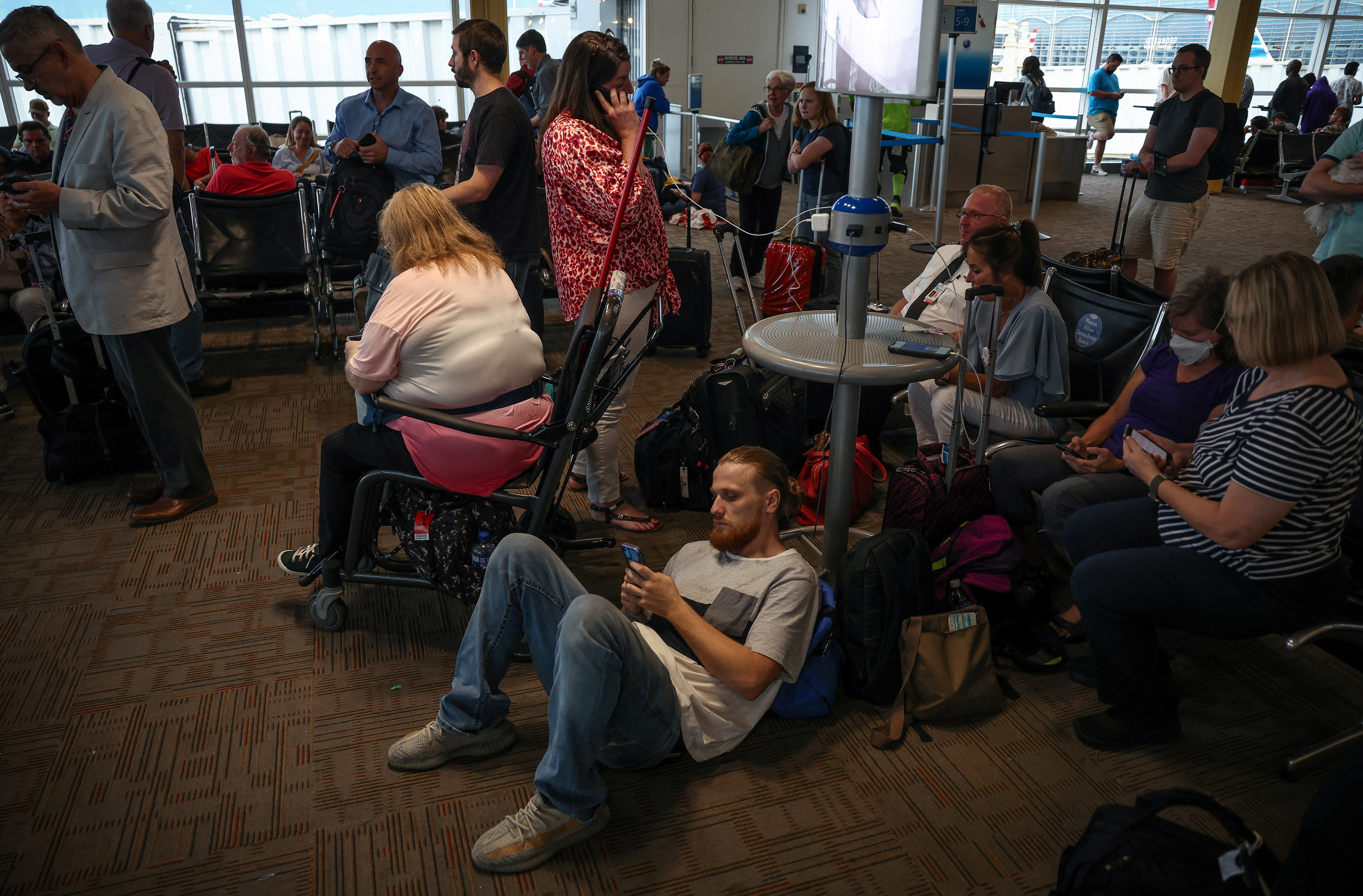 Delayed travelers wait for air traffic to resume at Ronald Reagan Washington National Airport ahead of the July 4th holiday weekend in Arlington, Virginia, U.S., June 30, 2023. REUTERS/Evelyn Hockstein