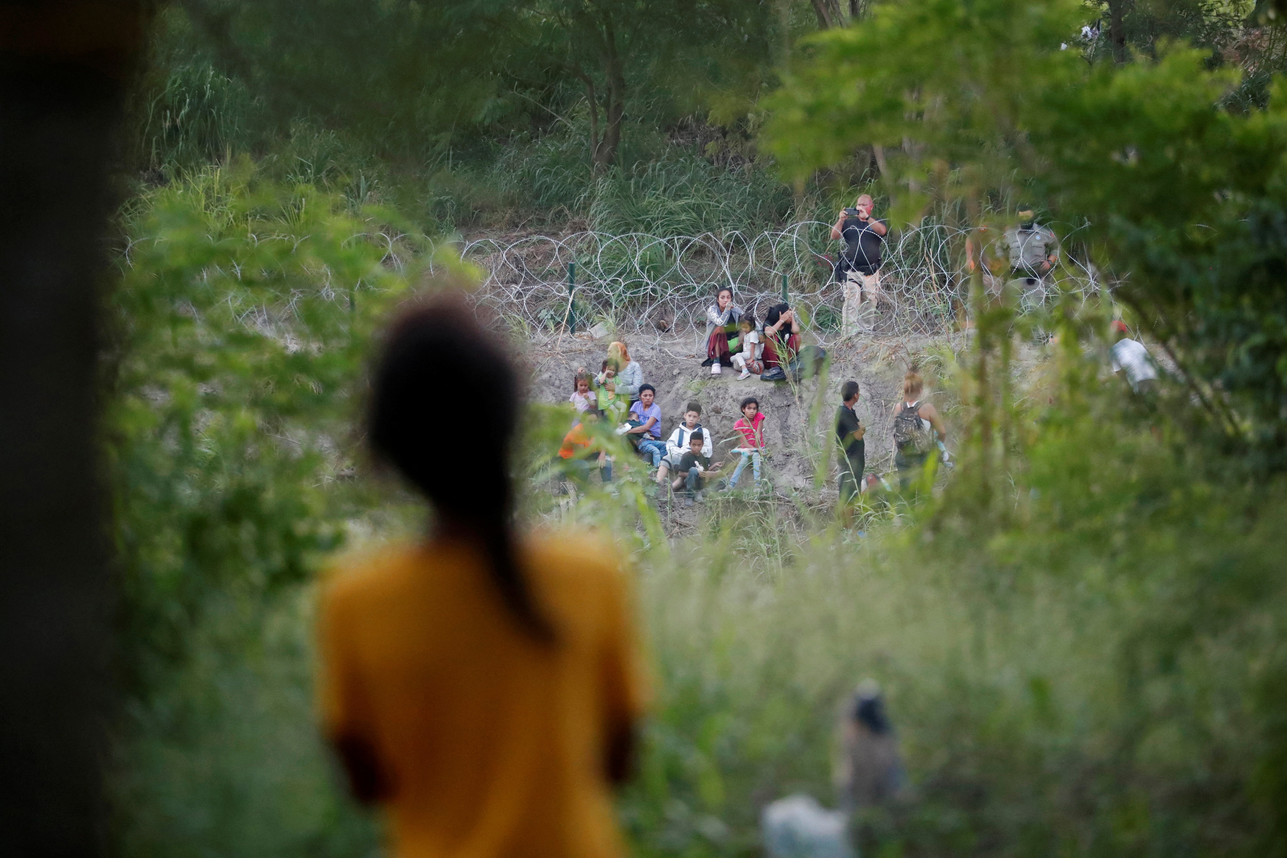 Venezuelan asylum seeker Nathaly, 13, observes a group of migrants being turned back to Mexico by U.S. border patrol agents, while she and her family wait to attempt to cross into the U.S. by an appointment through the Customs and Border Protection app, called CBP One, at a makeshift camp, in Matamoros, Mexico June 21, 2023. President Joe Biden promised to replace the hardline policies of former President Donald Trump, including the COVID-era public health order Title 42, with a more humane immigration system. The new Biden regulation allows migrants once again to ask for asylum at the border, but wait in Mexico for a slot on the app or risk a sped-up deportation process that could be conducted while they are held in detention. But in the first month of the new policy, Reuters found tens of thousands of people are waiting in dangerous Mexican border towns to snag a spot on the app, according to U.S. and Mexican officials, amid warnings from humanitarian groups of deteriorating sanitary conditions at migrant camps. REUTERS/Daniel Becerril