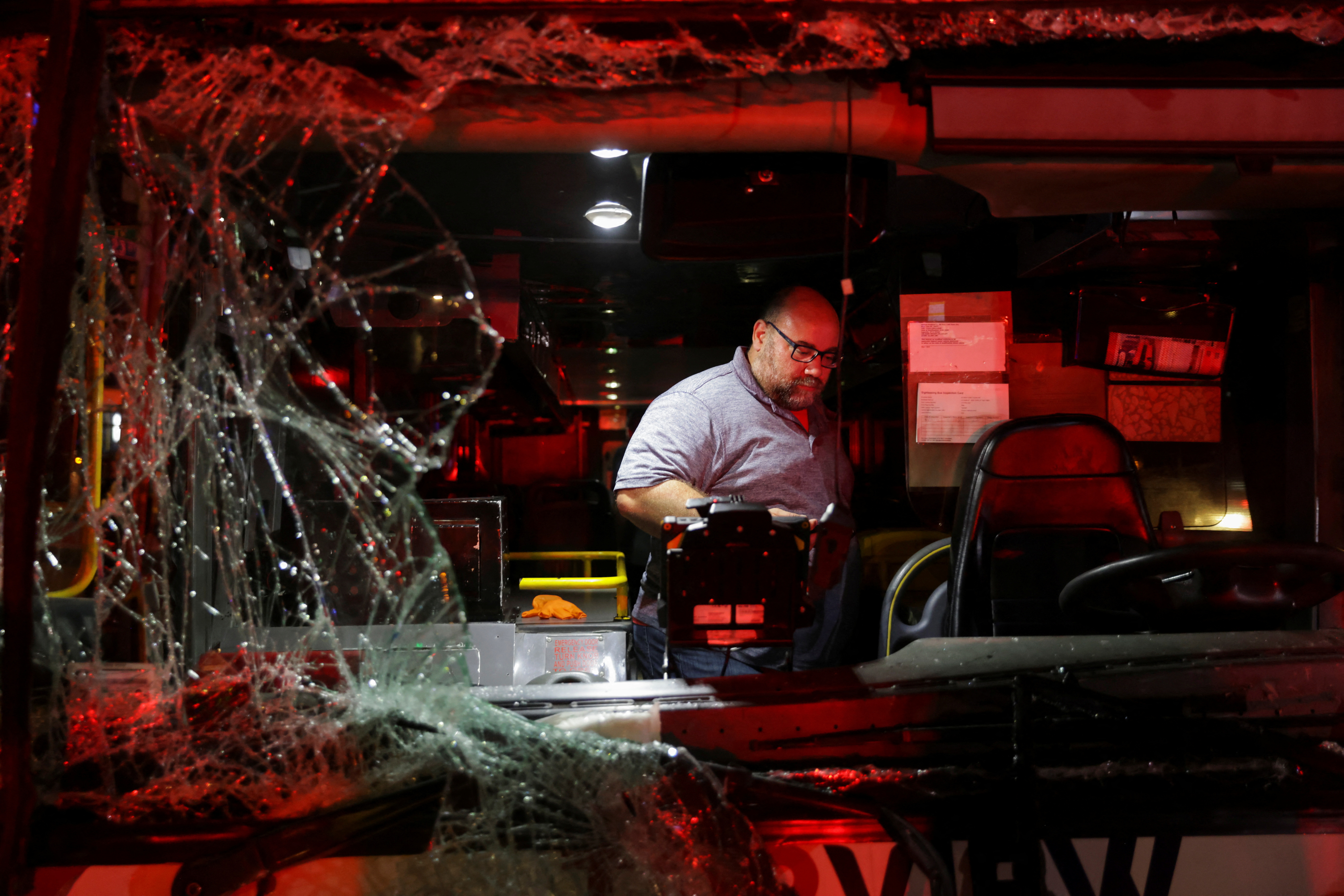 A man is seen through the broken windshield of a bus at the site of a bus crash between a tourist double decker bus and a city bus in the Manhattan borough of New York City, U.S., July 6, 2023. REUTERS/Jeenah Moon