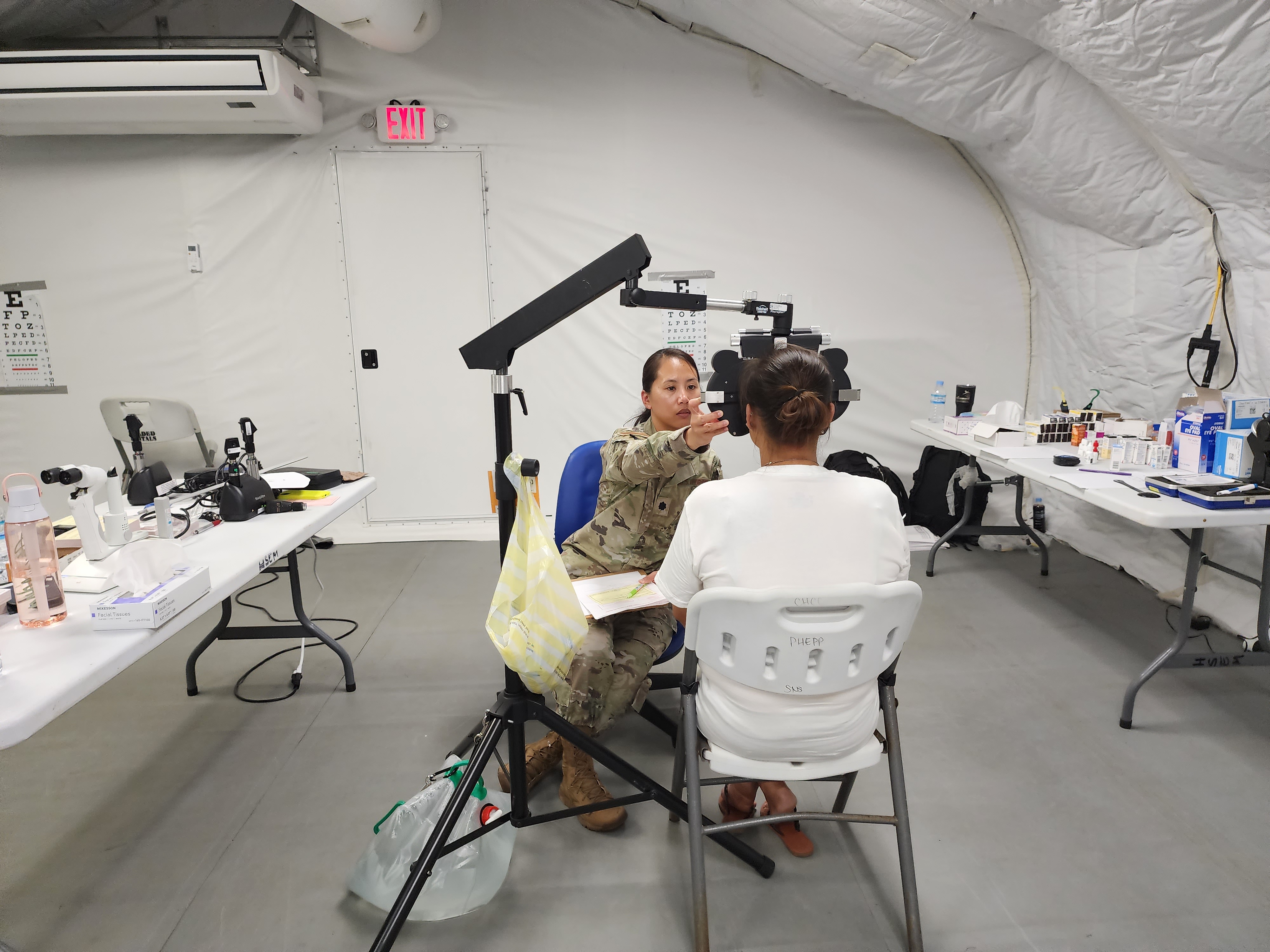 A medical staff member attends to an optometry patient.