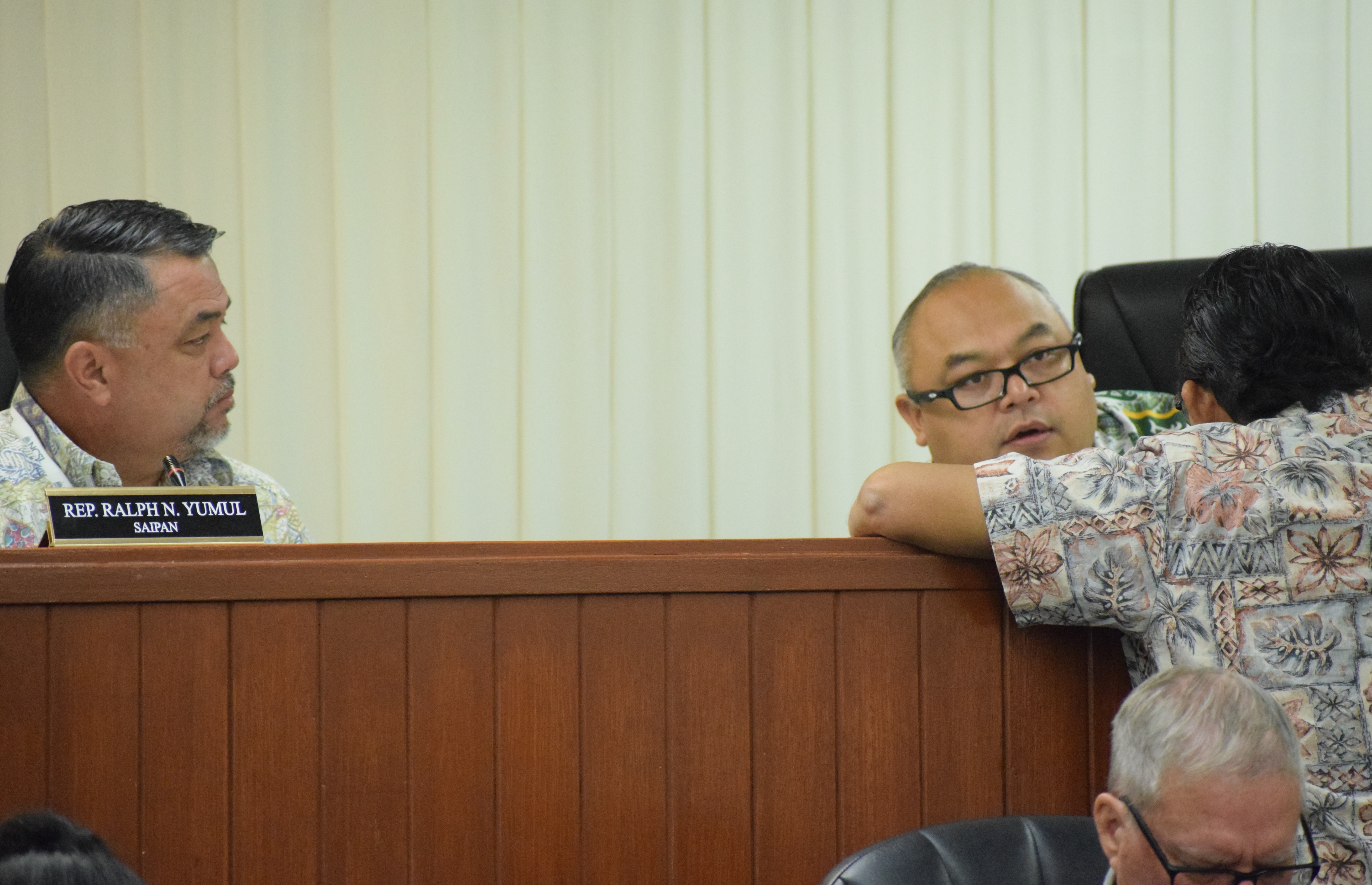 House Ways and Means Committee Chairman Ralph N. Yumul, left, and Vice Chairman Blas Jonathan Attao, right, confer with Tinian Rep. Patrick San Nicolas during a committee meeting on Monday in the House chamber. 