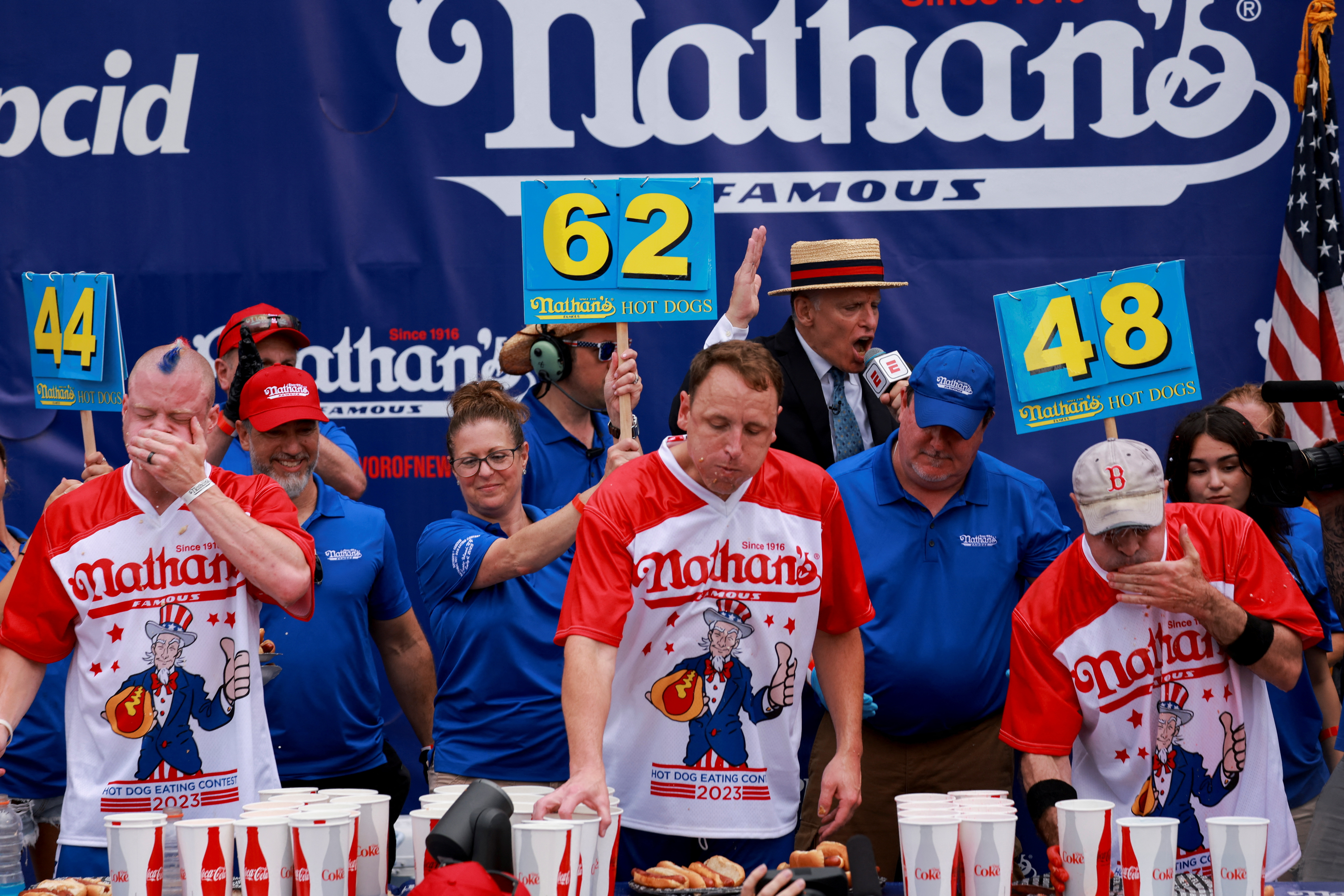 Nick Wehry, World Champion Joey Chestnut and Geoffrey Esper compete in  Nathan's Famous Fourth of July International Hot Dog Eating Contest at Coney Island in New York City, July 4, 2023.