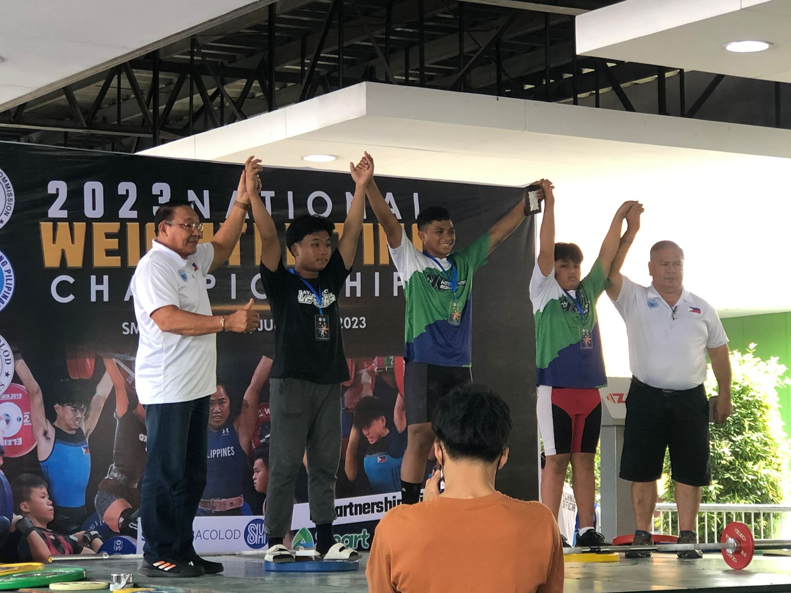 Aiden Gimed, center, poses with his gold medal during the awards ceremony of the Philippine National Weightlifting Championship in Bacolod, in the central Philippines on Saturday.