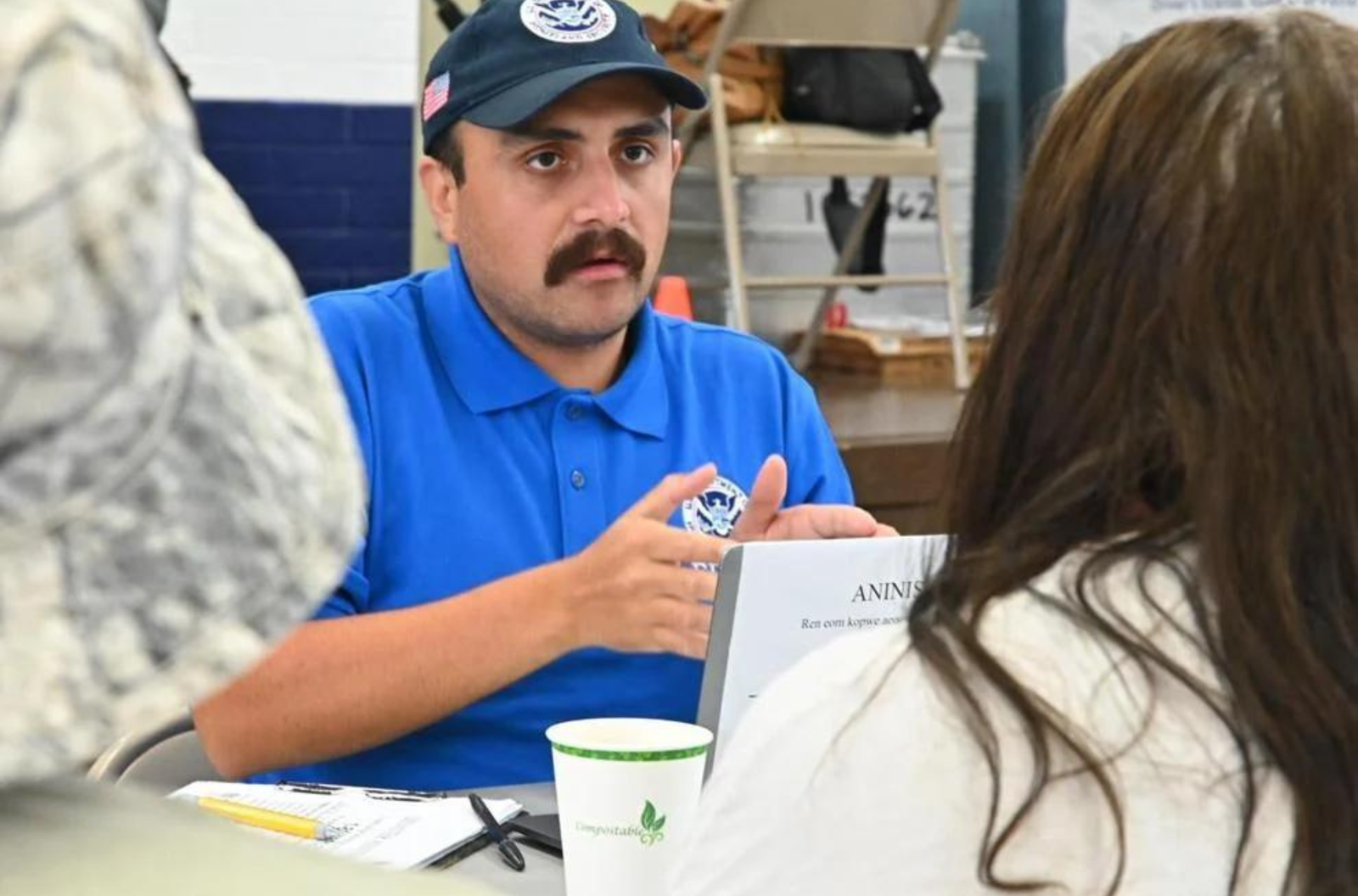 Federal Emergency Management Agency Applicant Services Program Specialist Jorge, from New Hampshire, helps a person with their application at the Juan M. Guerrero Elementary School FEMA Disaster Recovery Center Sunday, June 25, 2023, in Dededo. 