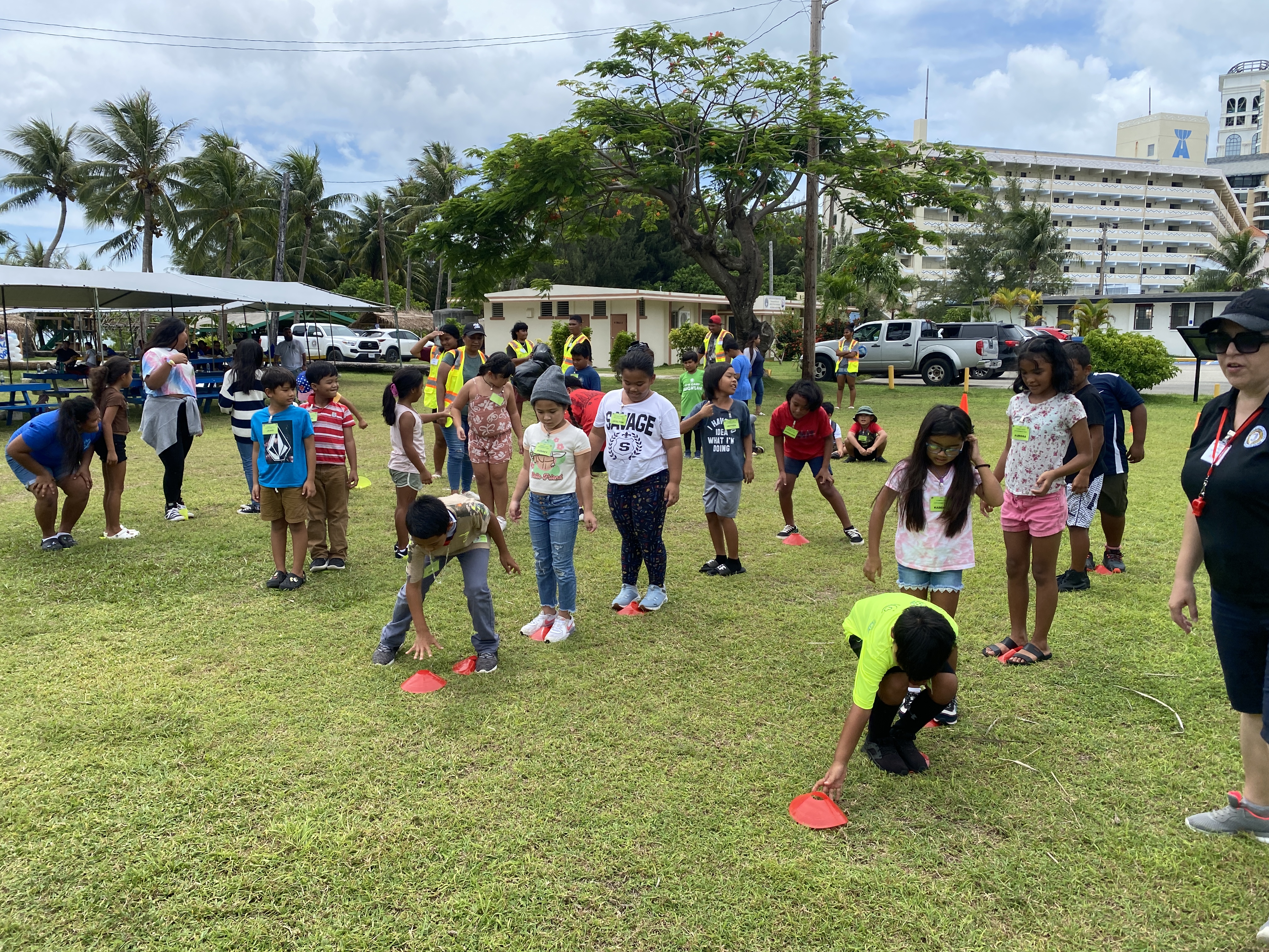 Children race to be the first team to cross the finish line at the 2023 Summer Youth Empowerment Camp. They were only allowed to move by stepping atop the plastic cones.
