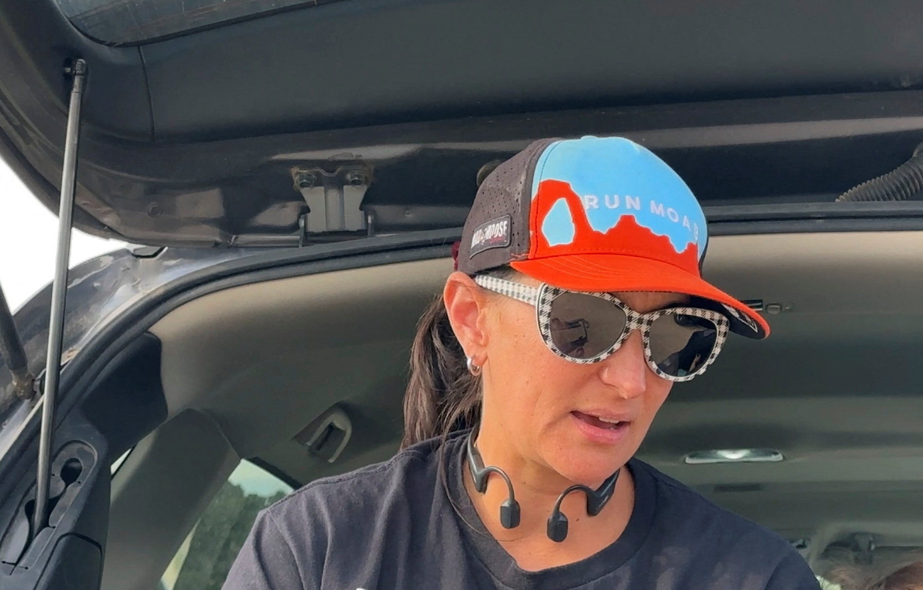 Trail runner and community volunteer Emily Matheu sits in the back of her car at a meet up of mountain bikers at Horsethief Mesa, north of Taos, New Mexico, U.S., June 28, 2023 in this screengrab from a video. REUTERS/Andrew Hay