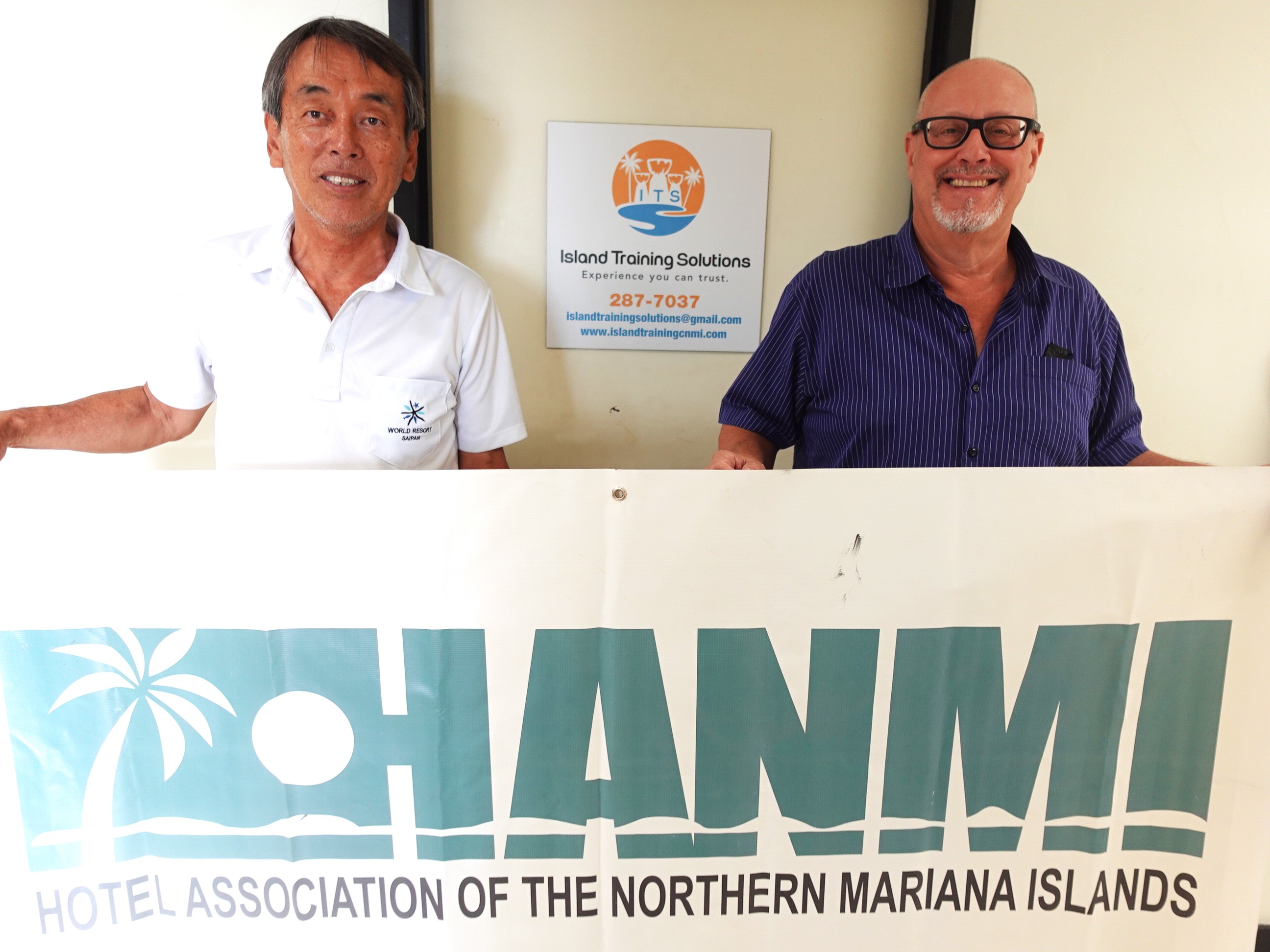 Island Training Solutions owner Jim Arenovski presents a $5,000 hole-in-one prize on July 10, 2023, to tournament committee chairman Juko Ishikawa for the 21st Annual HANMI Charity Classic Golf Tournament, slated for July 15, 2023, at LaoLao Bay Golf & Resort.
