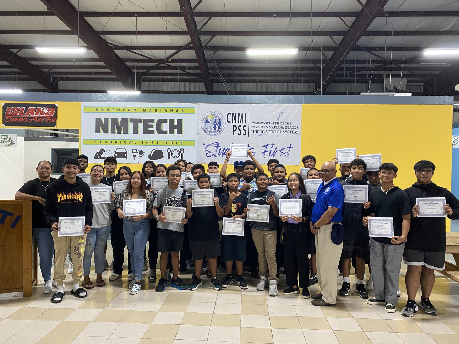 Student participating in  the Summer Tech Exploratory HVAC and Carpentry program pose for a photo with Northern Marianas Technical Institute CEO Jodina Attao, left, and Board of Education Vice Chair Herman Atalig, front row, right.