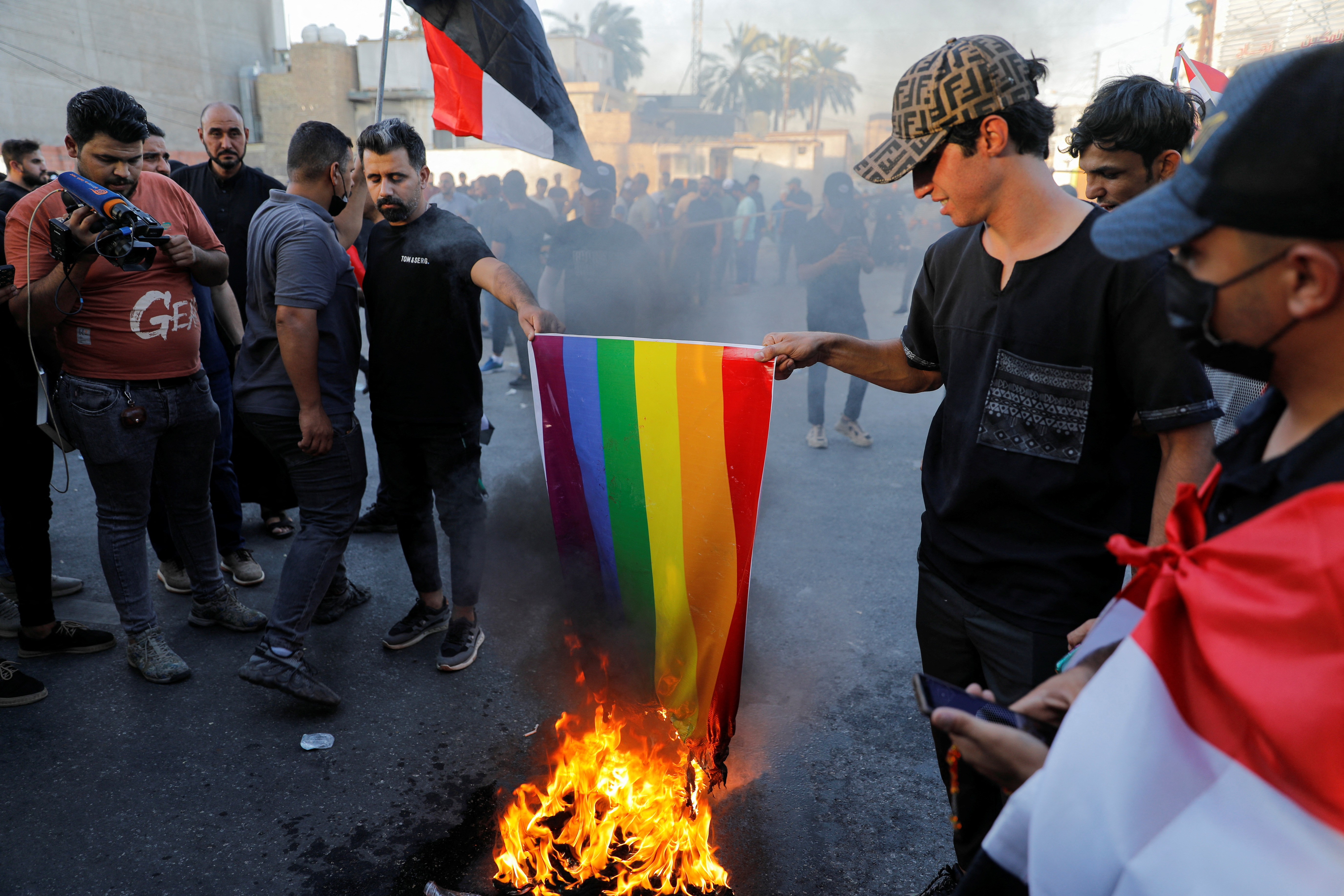 Iraqi demonstrators burn an LGBT flag during a protest near the Green Zone against the burning of a copy of the Koran and the Iraqi flag in the Swedish capital Stockholm, in Baghdad, Iraq July 22, 2023. REUTERS/Khalid Al-Mousily
