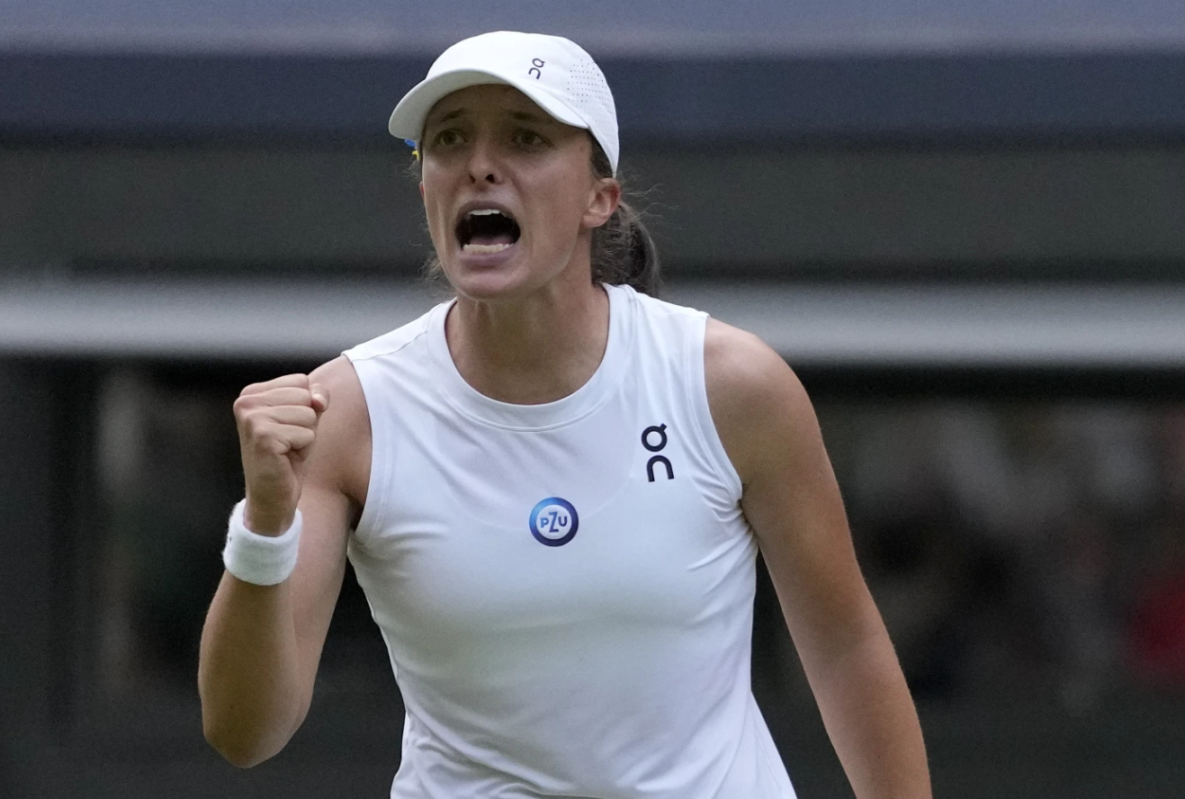 Poland’s Iga Swiatek celebrates after beating Switzerland’s Belinda Bencic in a women’s singles match on day seven of the Wimbledon tennis championships in London, Sunday, July 9, 2023.