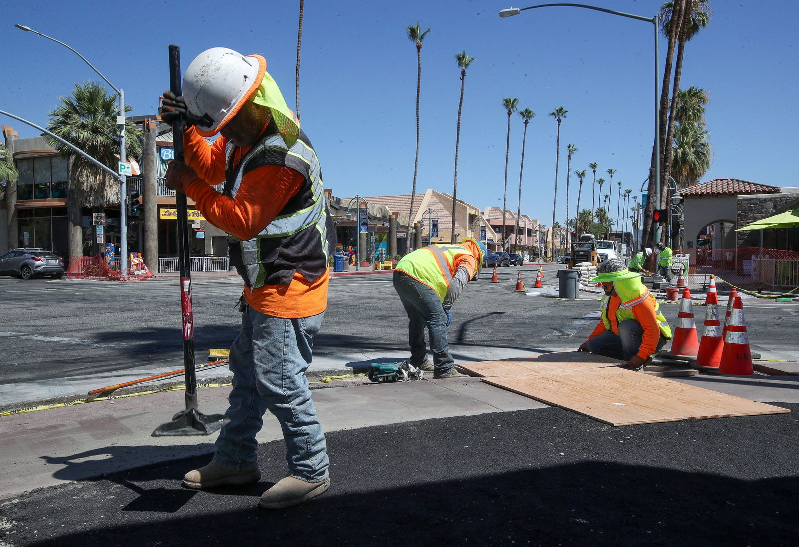 Carlos Sandoval and other construction workers work in temperatures that were over 100 degrees F (37 degrees C) as they install new sidewalk infrastructure in downtown Palm Springs, California, U.S. July 11, 2023. Jay Calderon/USA Today Network via REUTERS