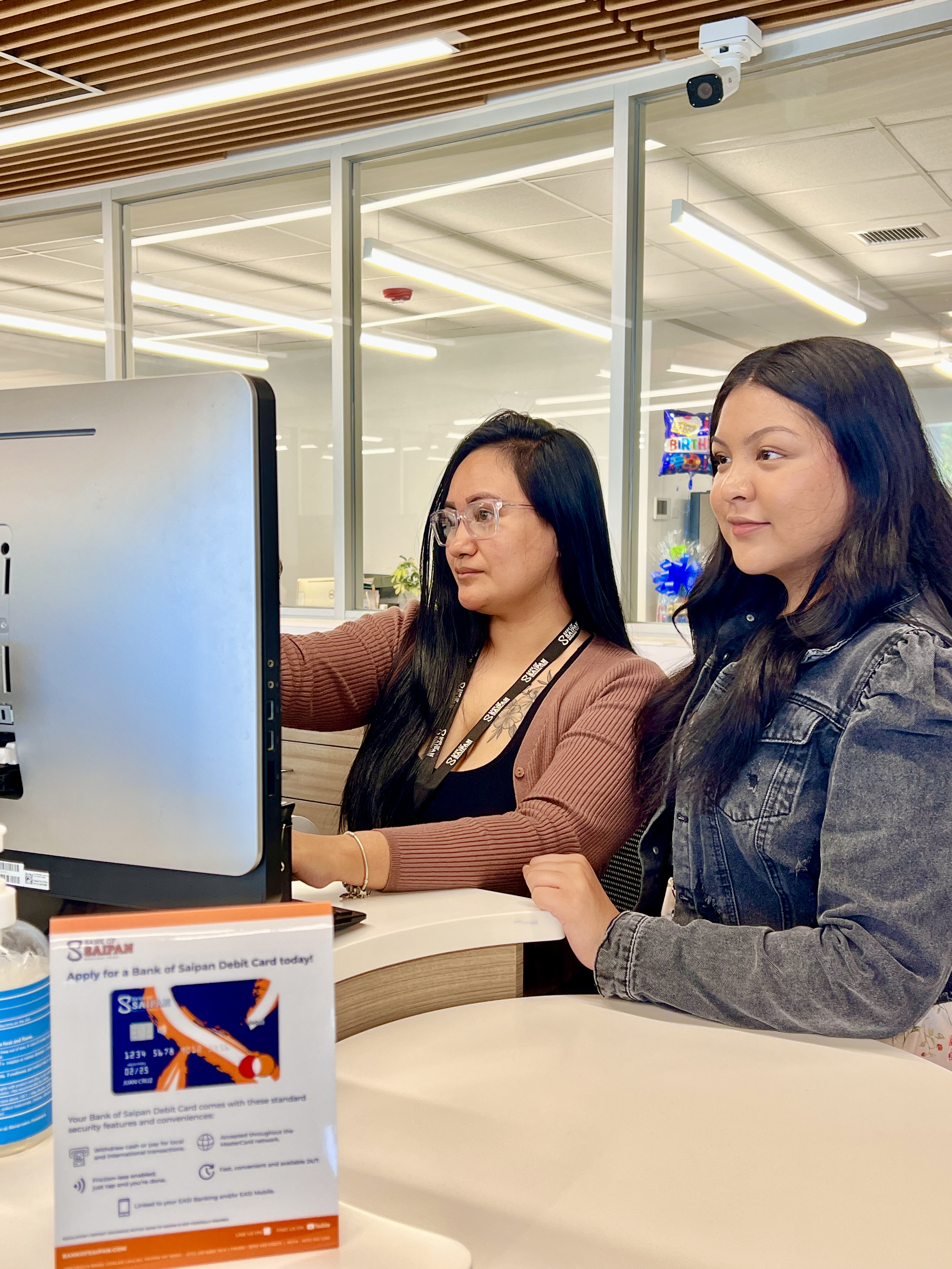 Student-intern Khate Bernardo, 17, of Marianas High School is guided by Bank of Saipan teller Melanie Basa.