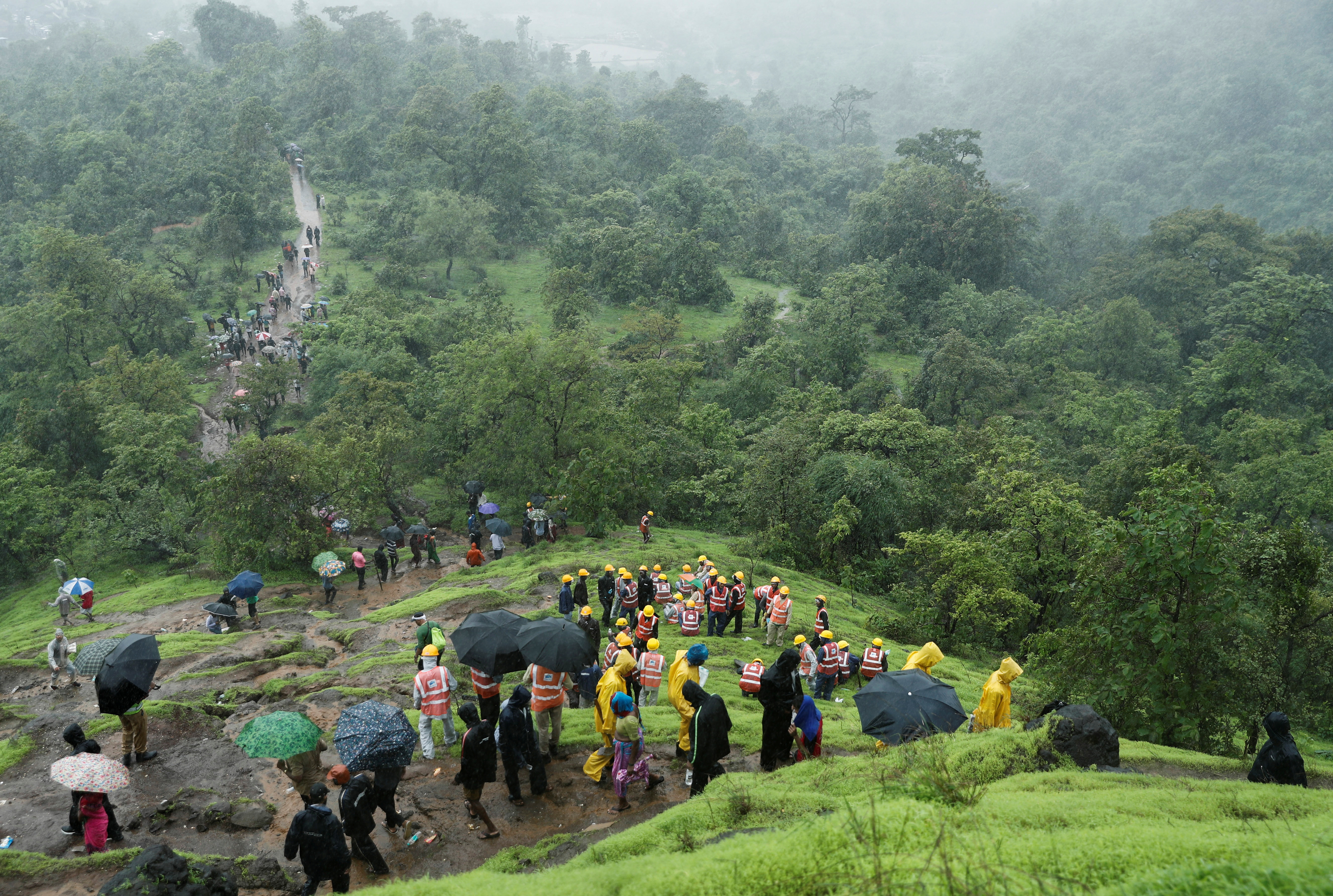 National Disaster Response Force (NDRF) personnel and other volunteers climb up a mountain to reach the site of a landslide at a village in Raigad, in the western state of Maharashtra, India July 20, 2023. REUTERS/Francis Mascarenhas
