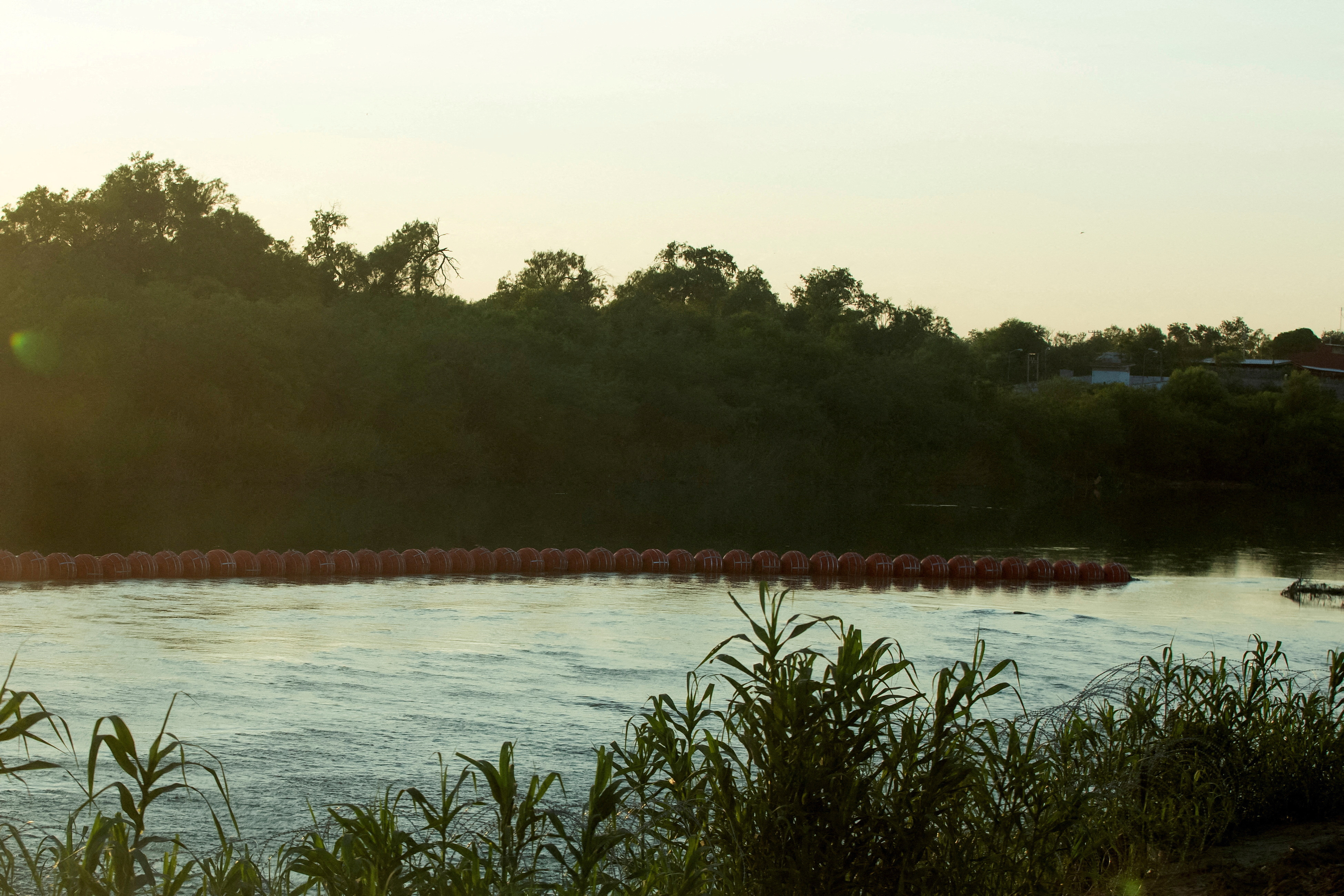 An unfinished strand of orange buoys sits in the Rio Grande River in response to migrants crossing the river, near Eagle Pass, Texas, U.S., July 11, 2023. REUTERS/Kaylee Greenlee Beal/File Photo