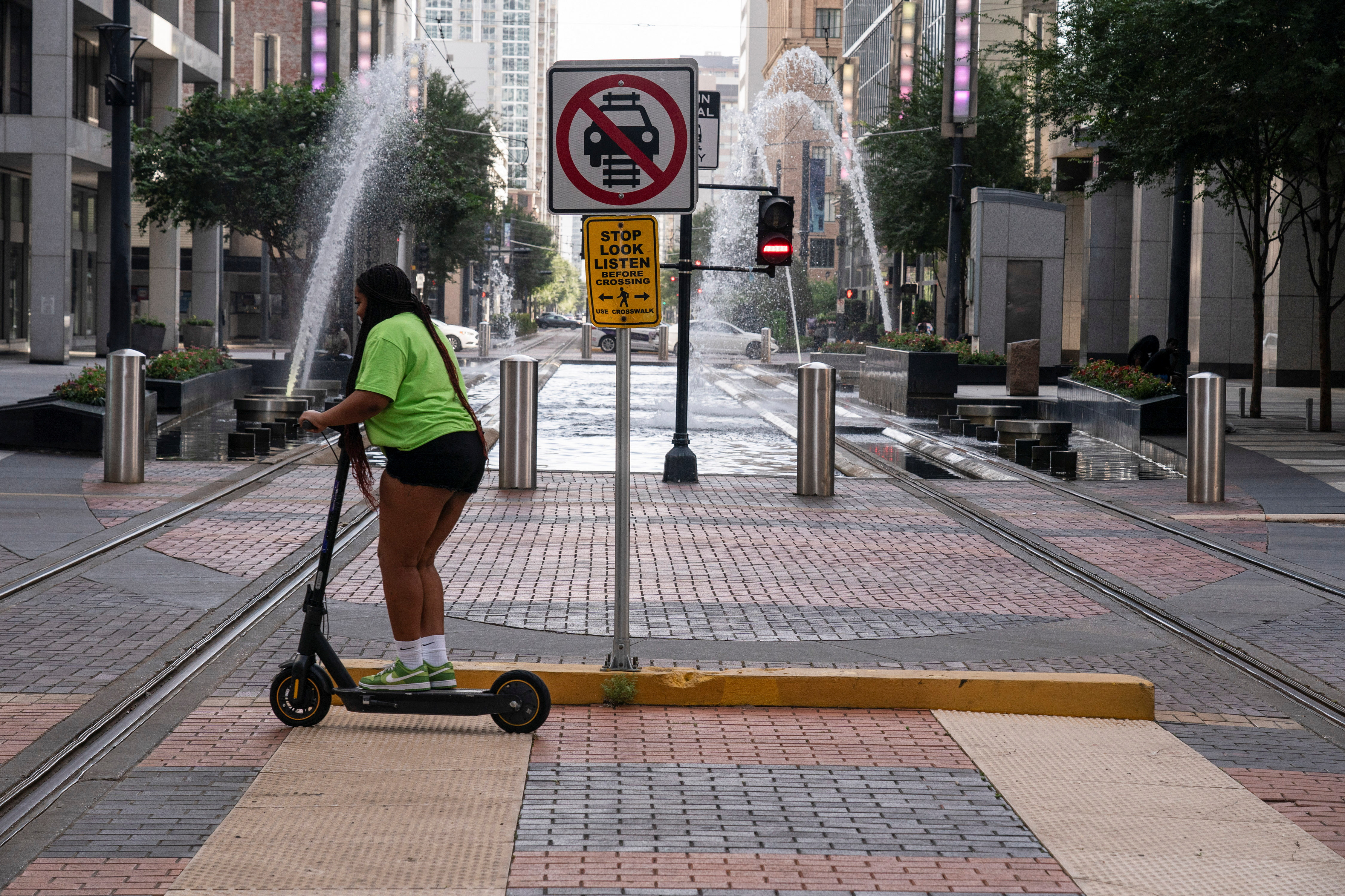 A person rides an electric kick scooter during excessive heat warnings for Southeast Texas in Houston, Texas, U.S. July 16, 2023. REUTERS/Go Nakamura