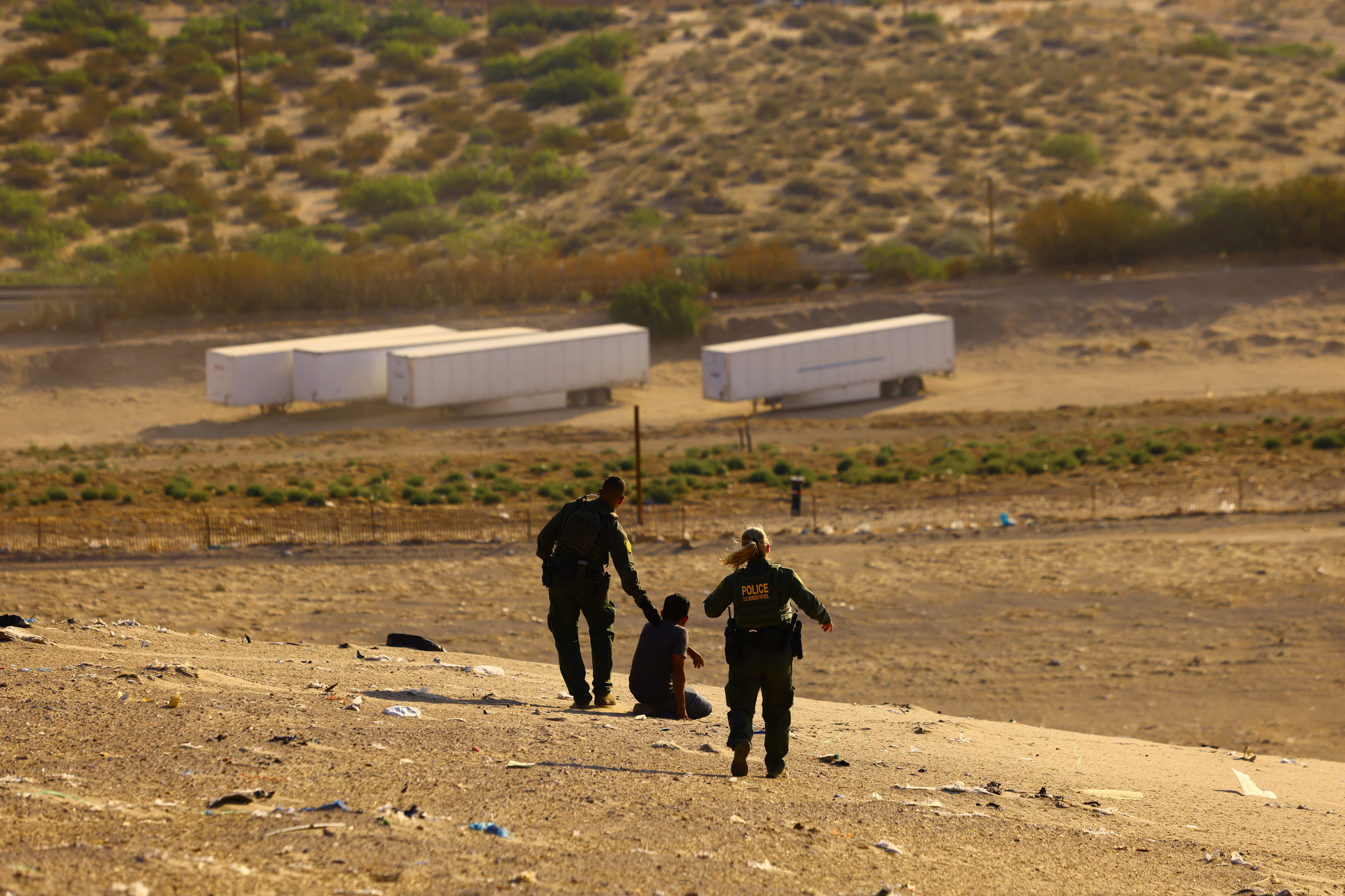 U.S. Border Patrol agents Sean Coffey and Marcia Finnegan apprehend a migrant who attempted to cross the U.S.-Mexico border without detection, near Mount Cristo Rey in Sunland Park, New Mexico, U.S. June 23, 2023. REUTERS/Jose Luis Gonzalez