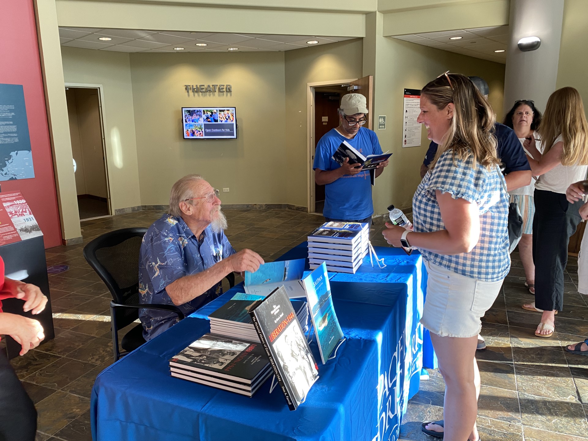 Seated at a table that displays his books, historian and author Don Farrell talks to an educator at the Visitor Center of American Memorial Park on Monday, July 10. Farrell is one of the lecturers in the “Saipan’s Land and Sea: Battle Scars & Sites of Resilience” program.