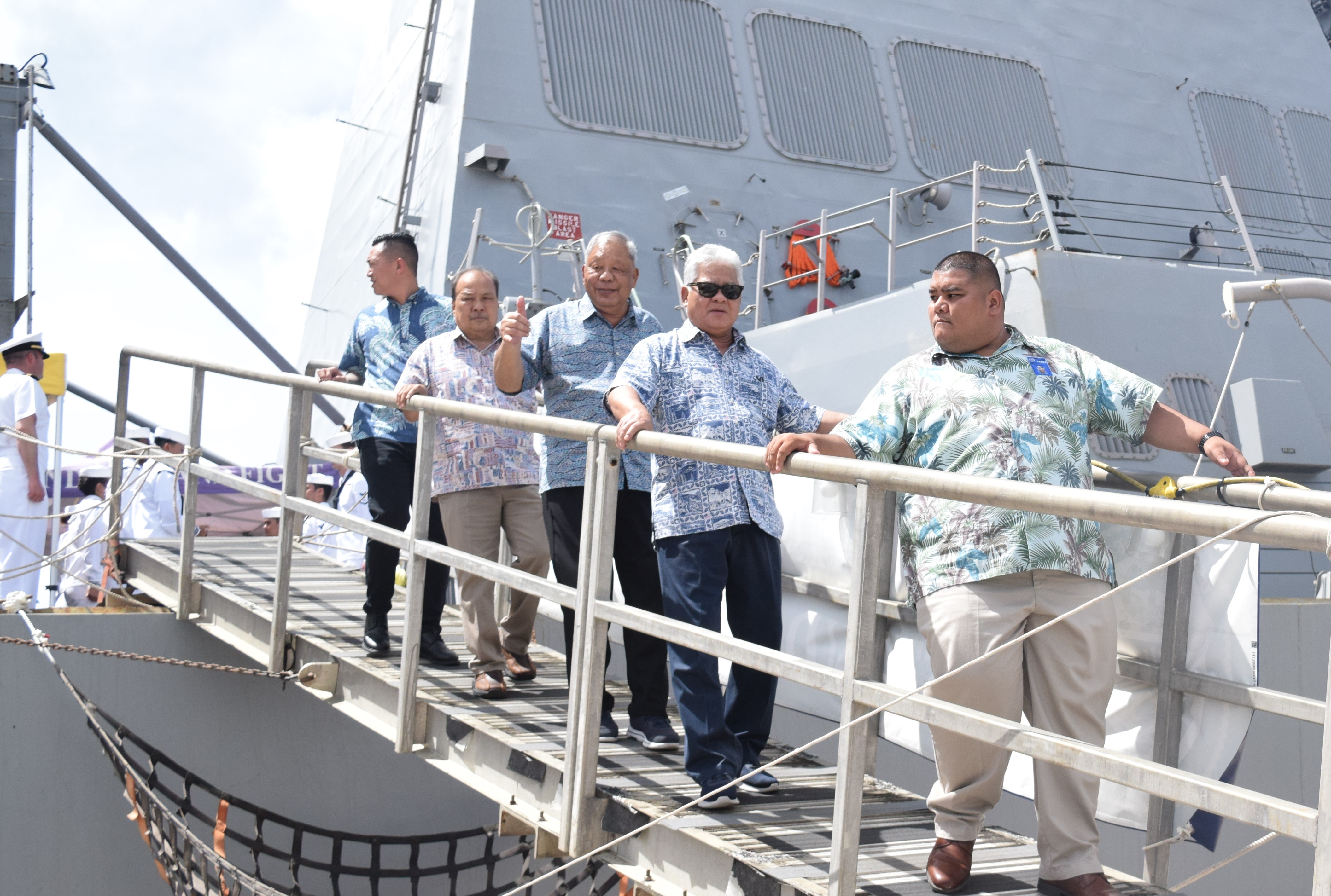 Gov. Arnold I. Palacios, second right, and Lt. Gov. David M. Apatang, center, are accompanied by their security aides as they disembark from the USS John Finn which made its first port call on Saipan on Sunday.
