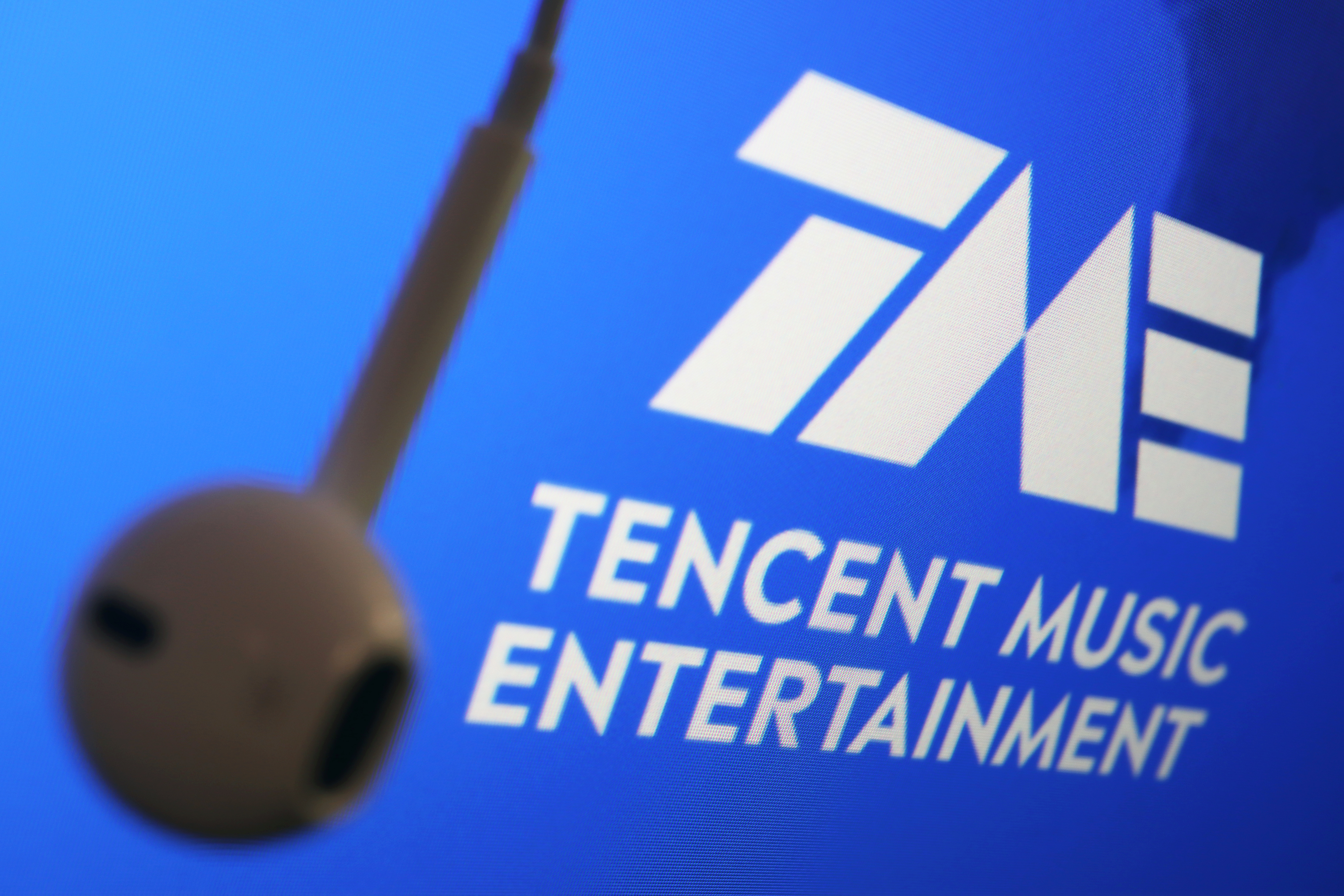 The logo of China's Tencent Music Entertainment Group is seen next to an earphone in this illustration picture taken March 22, 2021. REUTERS/Florence Lo/Illustration