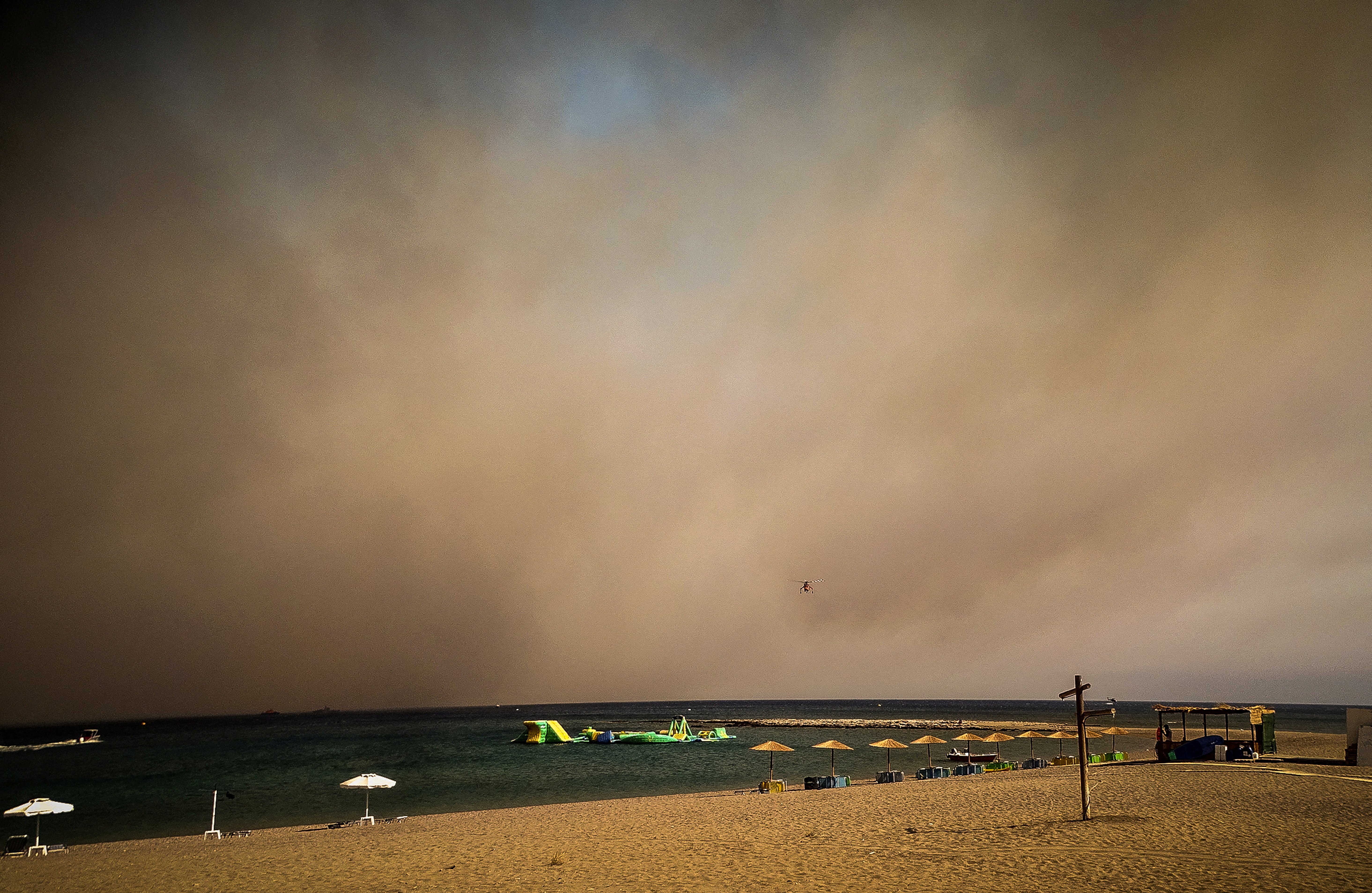 A beach is seen covered in smoke during a wildfire on the island of Rhodes, Greece, July 22, 2023. Argiris Mantikos/Eurokinissi via REUTERS
