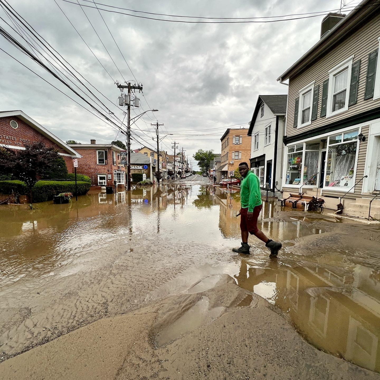 A person walks on a flooded road, in Highland Falls, Orange County, New York, U.S., July 9, 2023, in this still image from video obtained from social media. Marc Zahakos /via REUTERS