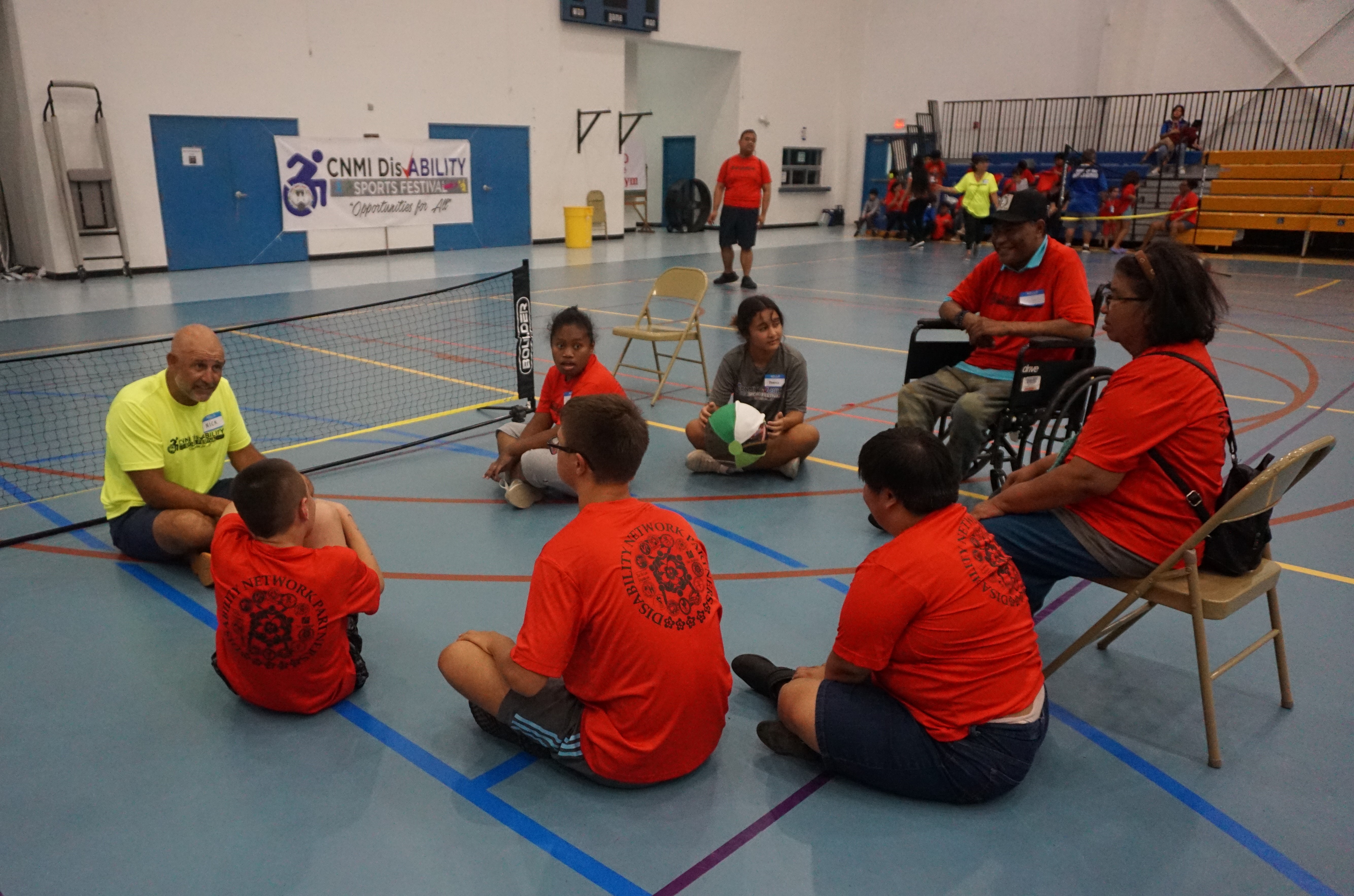 Nick Gross explains the rules of volleyball to a group of athletes during the 3rd CNMI Disability Sports Festival on Friday at the Marianas High School gym.