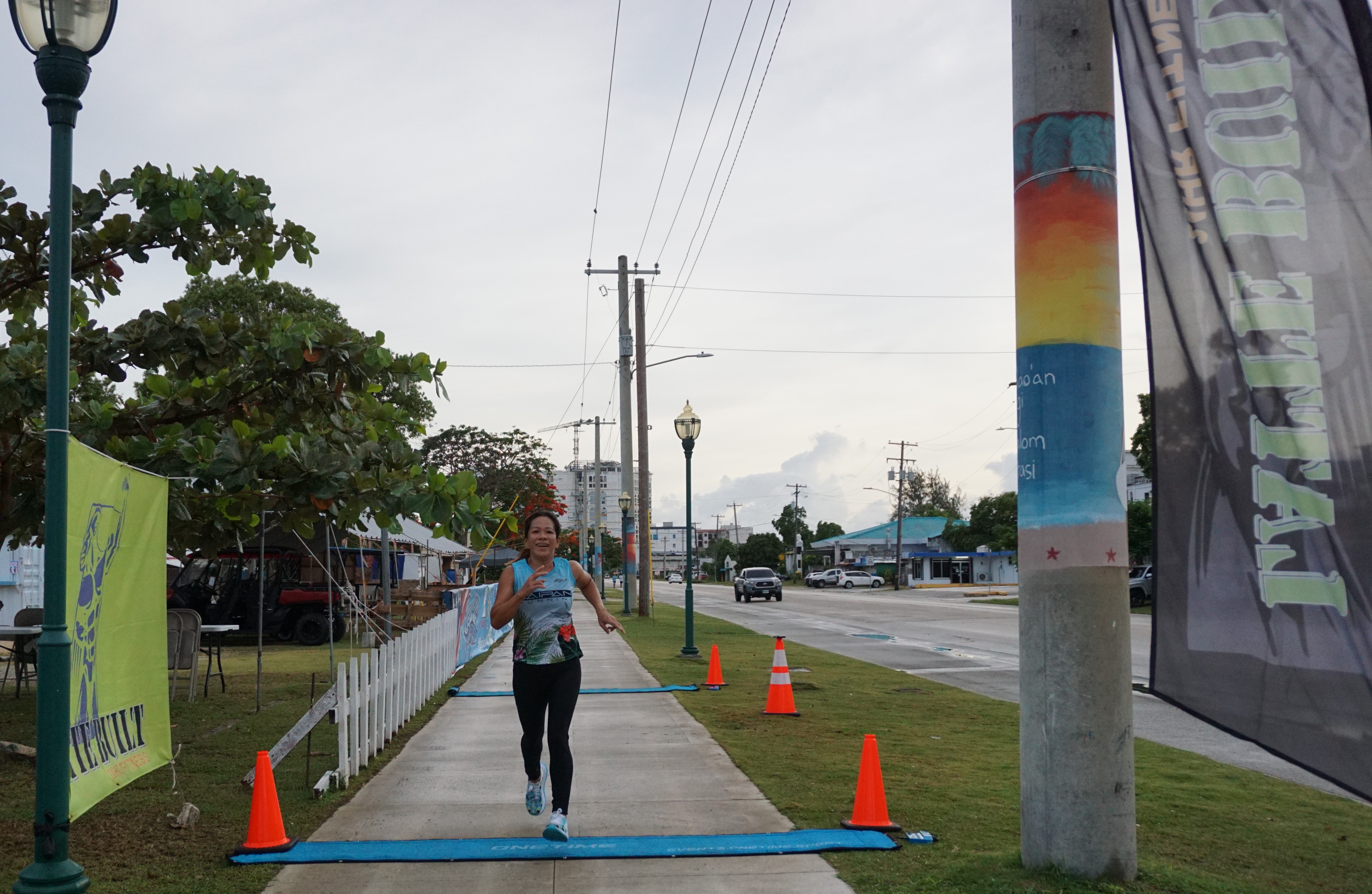Rosemarie Chisato crosses the finish line to top the women's division of the 3rd Annual 4th of July Independence Day 2-Mile Run on Tuesday morning at the Garapan Fishing Base.