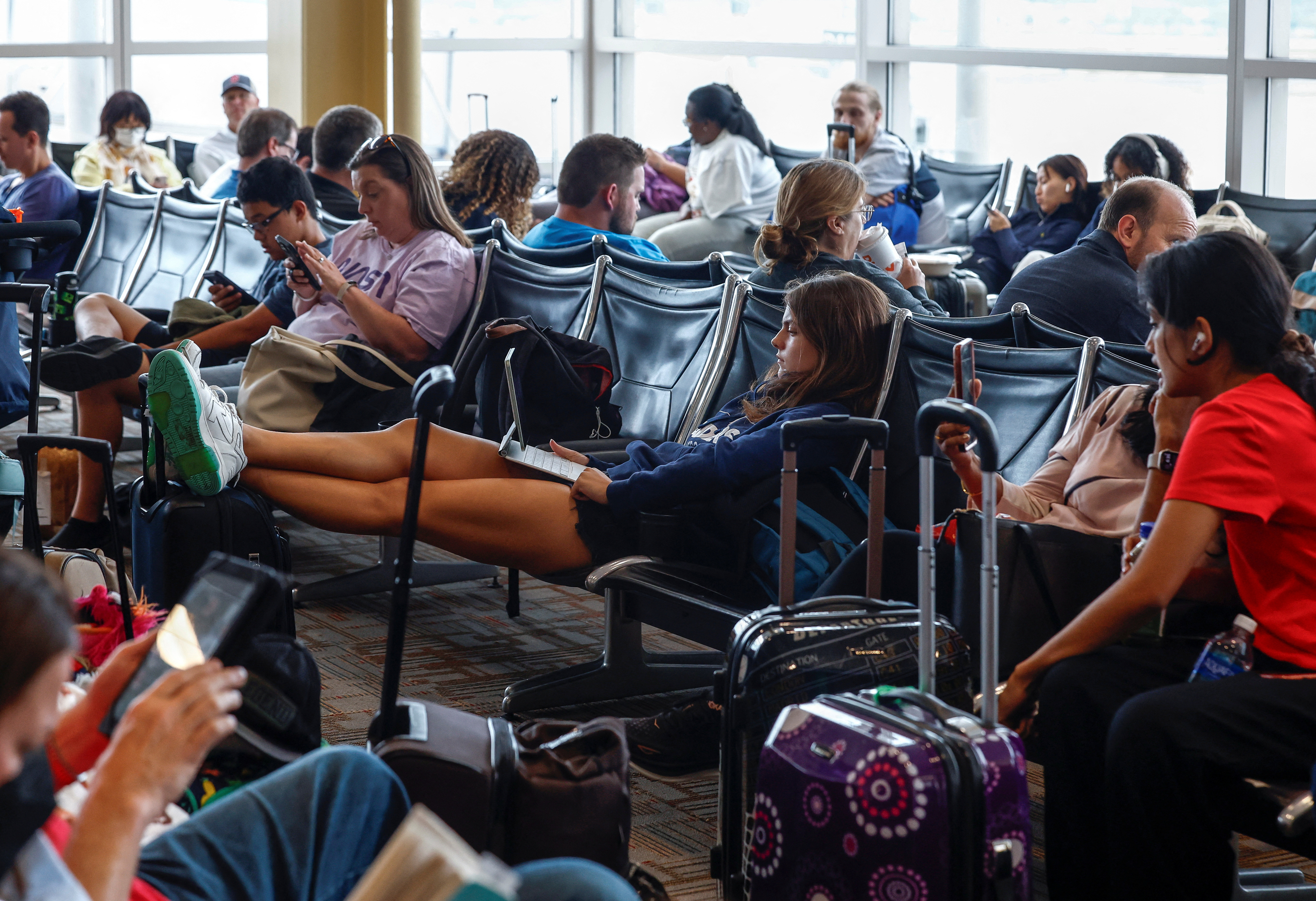 Delayed travelers wait for air traffic to resume at Ronald Reagan Washington National Airport ahead of the July 4th holiday weekend in Arlington, Virginia, U.S., June 30, 2023. REUTERS/Evelyn Hockstein