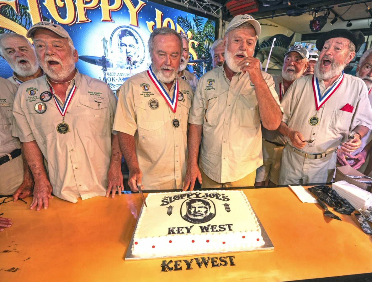 In this photo provided by the Florida Keys News Bureau, previous Hemingway Look-Alike Contest winners including, from left, David Douglas, Zach Taylor, and Jon Auvil, as well as honorary look-alike Brian Sinclair, sing “Happy Birthday” to Ernest Hemingway, Thursday, July 20, 2023, on the eve of the late author’s 124th birthday at Sloppy Joe’s Bar in Key West, Fla.