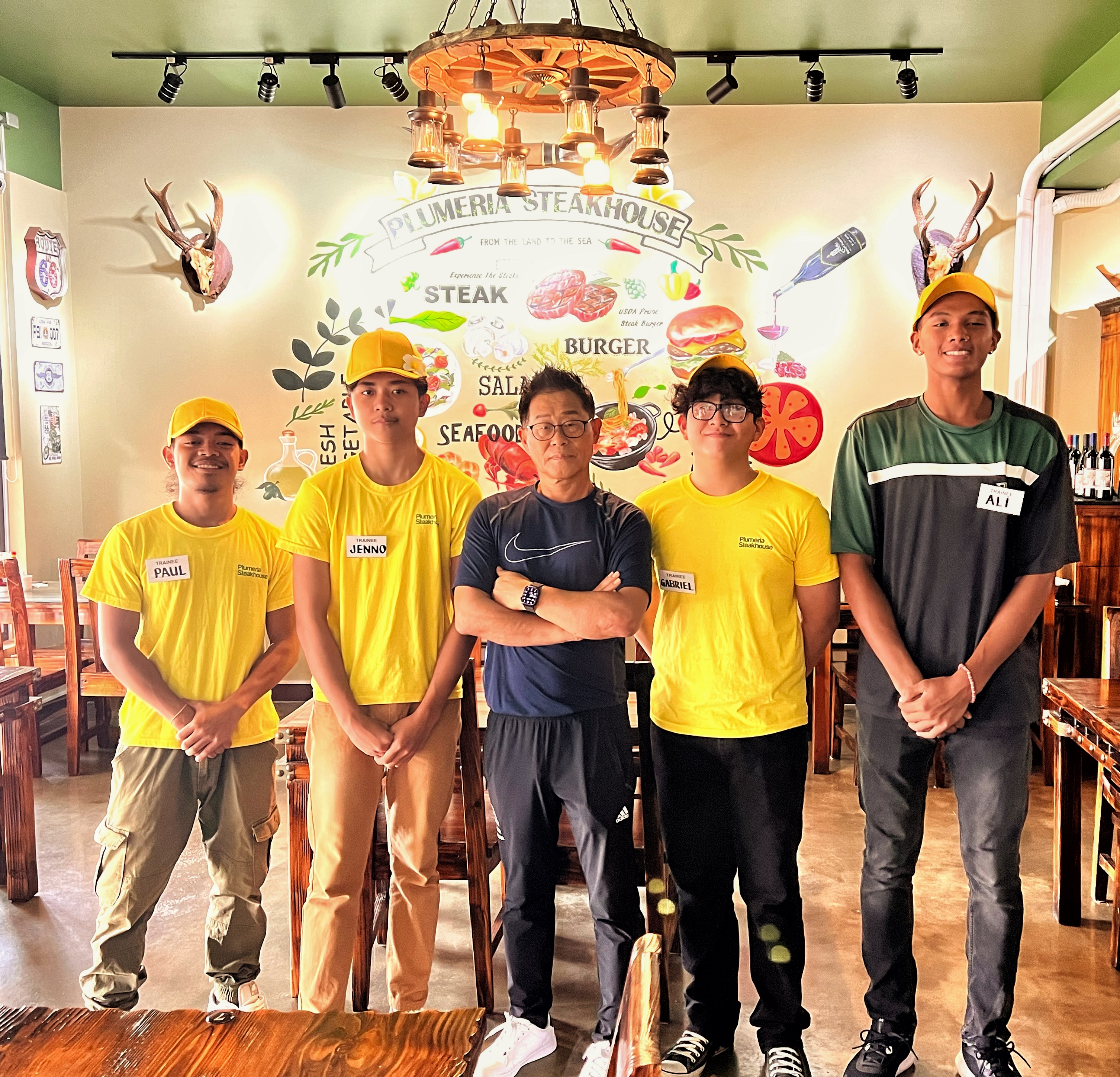 Plumeria Steakhouse proprietor Steve Jang poses with some of his student-interns.